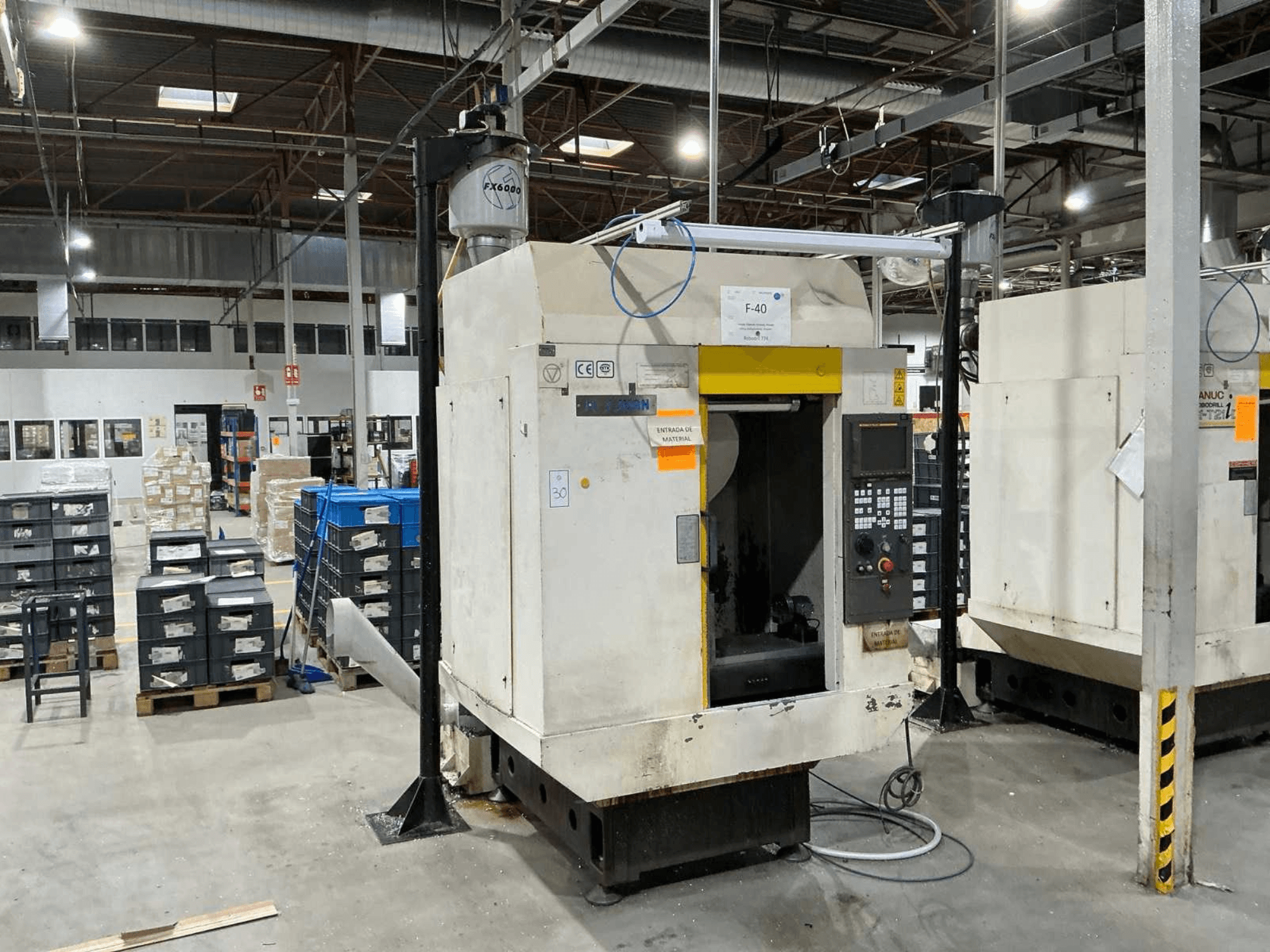 FANUC ROBODRILL α-T21iD, a függőleges megmunkálóközpont előlapja ipari környezetben, a vezérlőpanel részletei láthatóak.