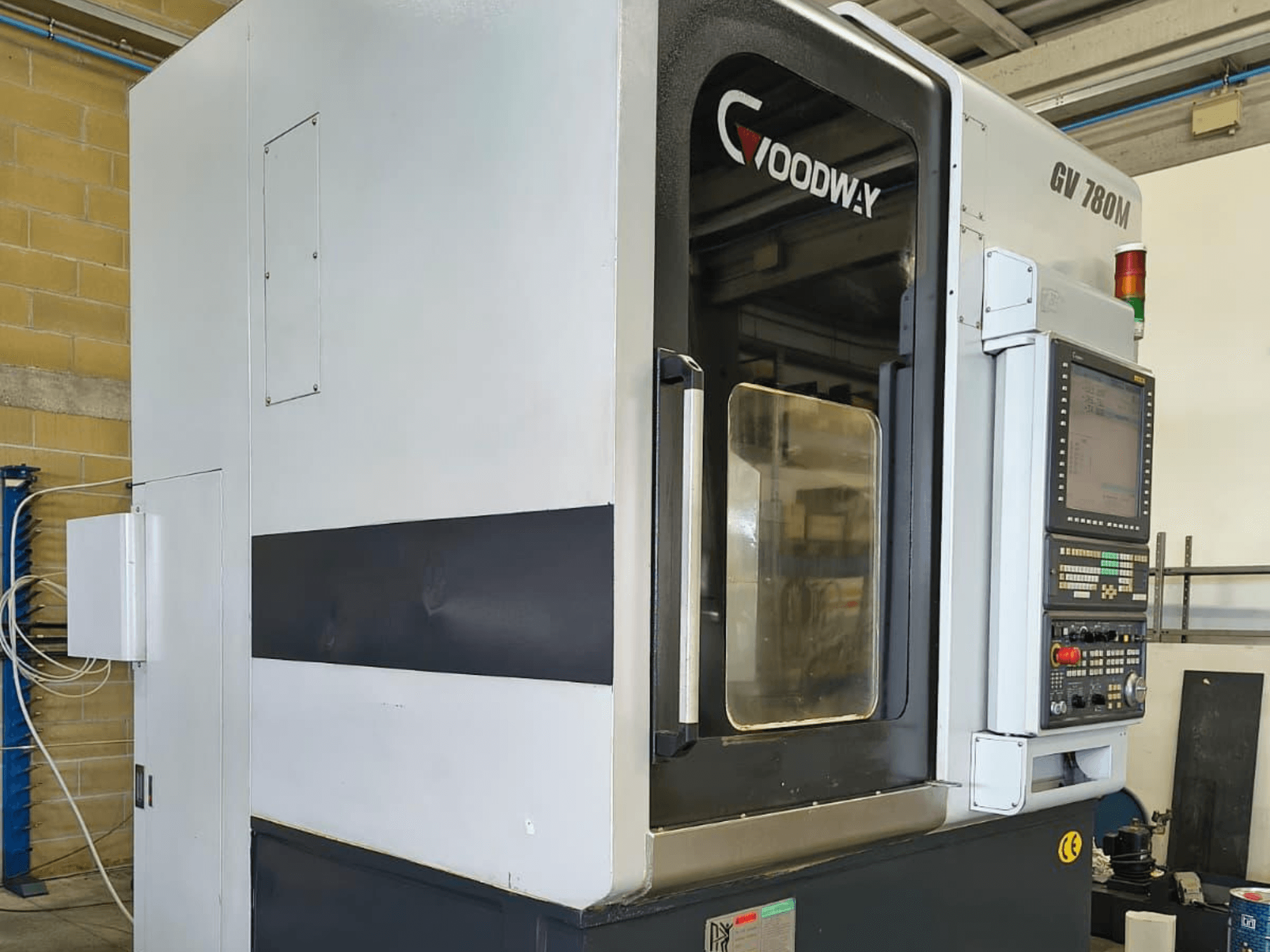 Goodway GV 780 M függőleges esztergagép, oldalnézet, a vezérlőpanel, a biztonsági funkciók és a letisztult külső kialakítás bemutatása.