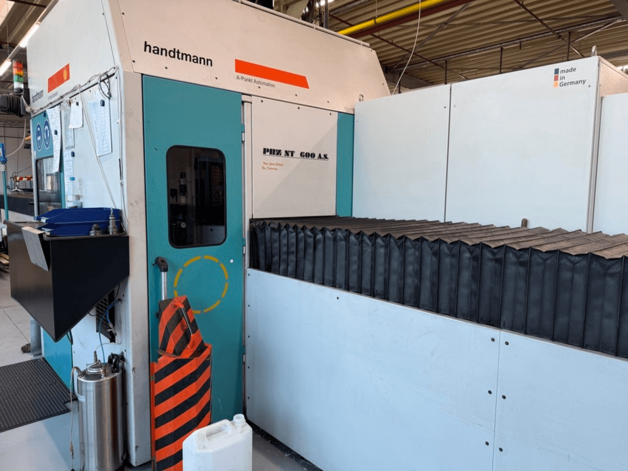 A Handtmann PBZ NT 600 AS portálmarógép elülső nézete, sötét munkafelülettel és biztonsági korlátokkal.