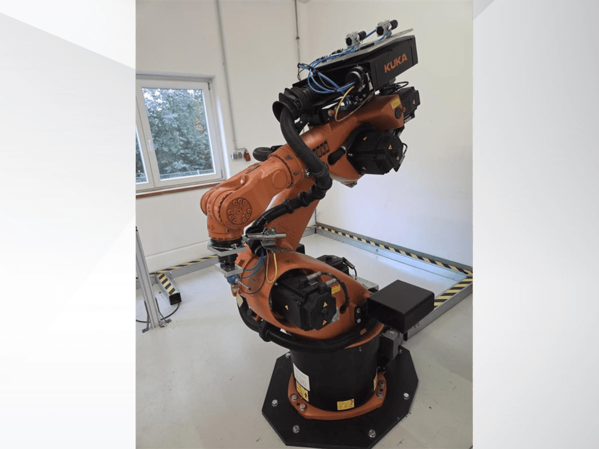 A KUKA KR60 HA robotkar oldalnézetben, az ipari alvázon elhelyezkedő mechanikus csuklók és vezetékek láthatók.