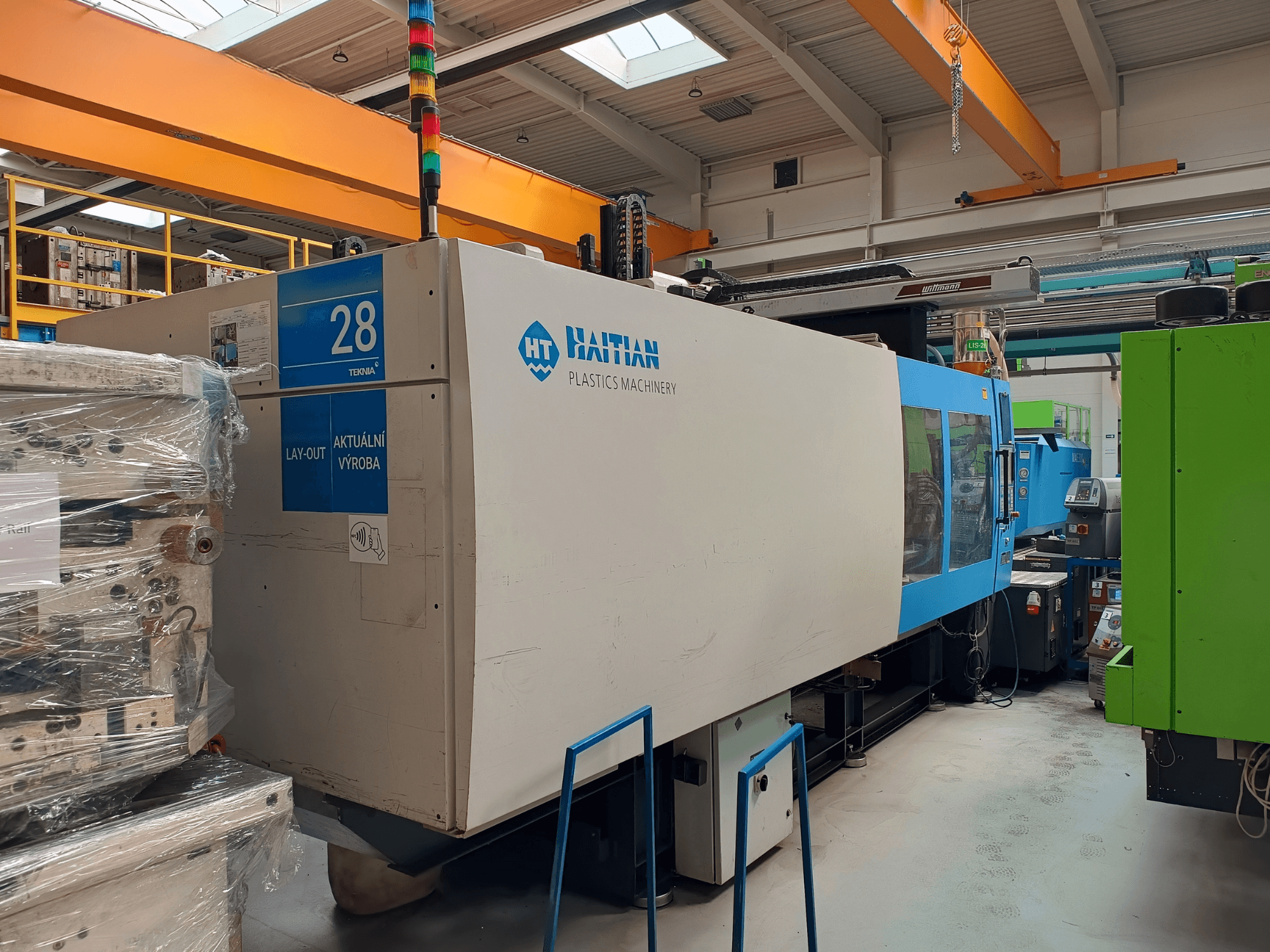 HAITIAN MARS 5300/4500 hidraulikus fröccsöntőgép, elölnézetből, a vezérlőpanel és a kék-fehér burkolat bemutatása.