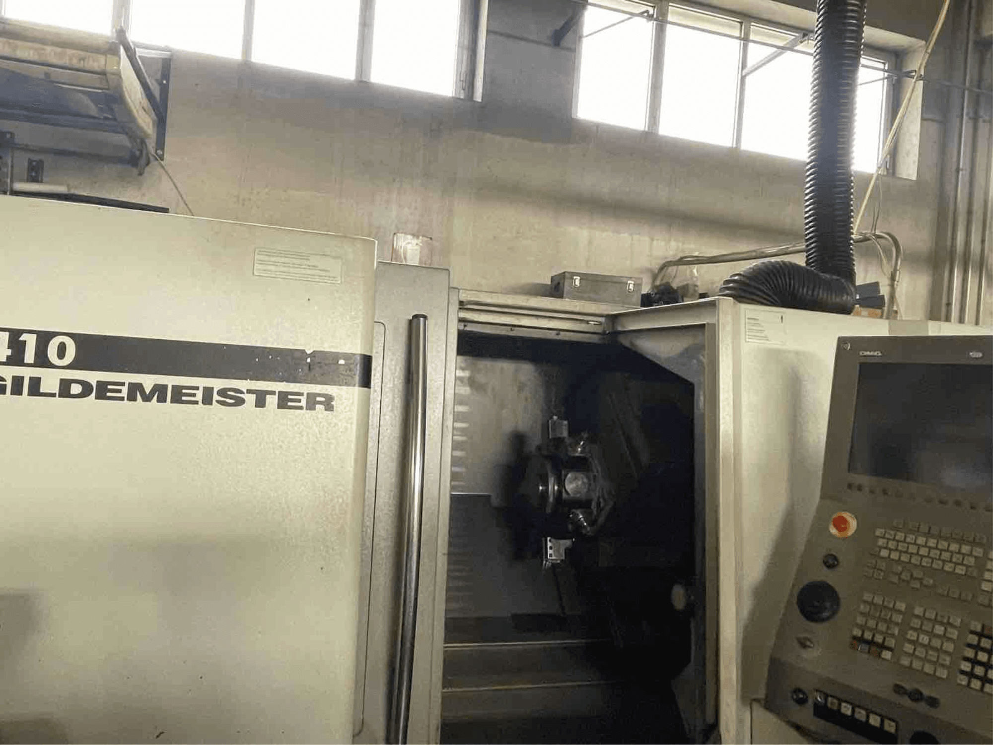 DMG CTX410 vízszintes esztergagép, előlnézet, a vezérlőpanel és a belsejében látható megmunkáló alkatrészek.