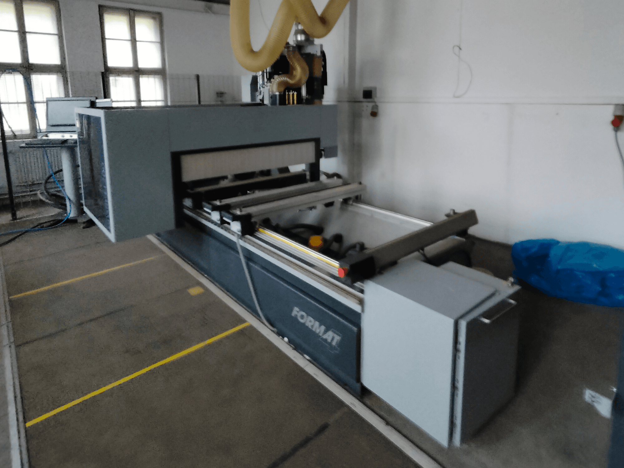 Egy szürke testű Format CNC-gép előlapja, vezetősínekkel és látható vezérlőpanellel.