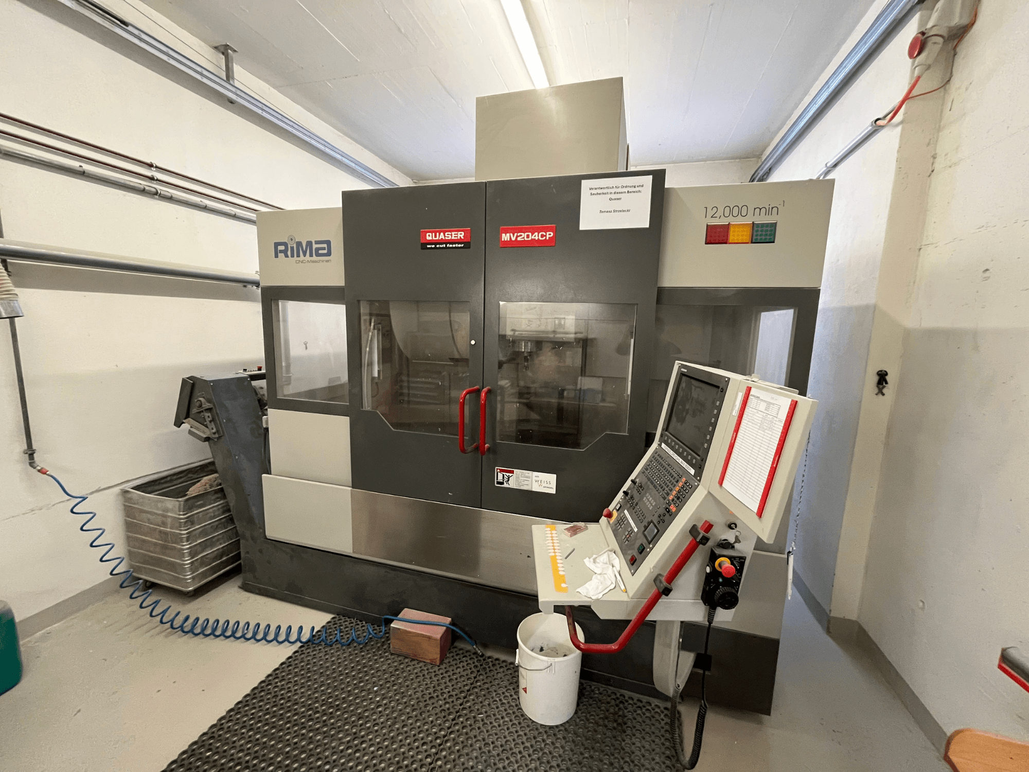 Quaser MV-204 CP függőleges megmunkálóközpont elölnézetből, a vezérlőpanel és a működési részletek megjelenítése.