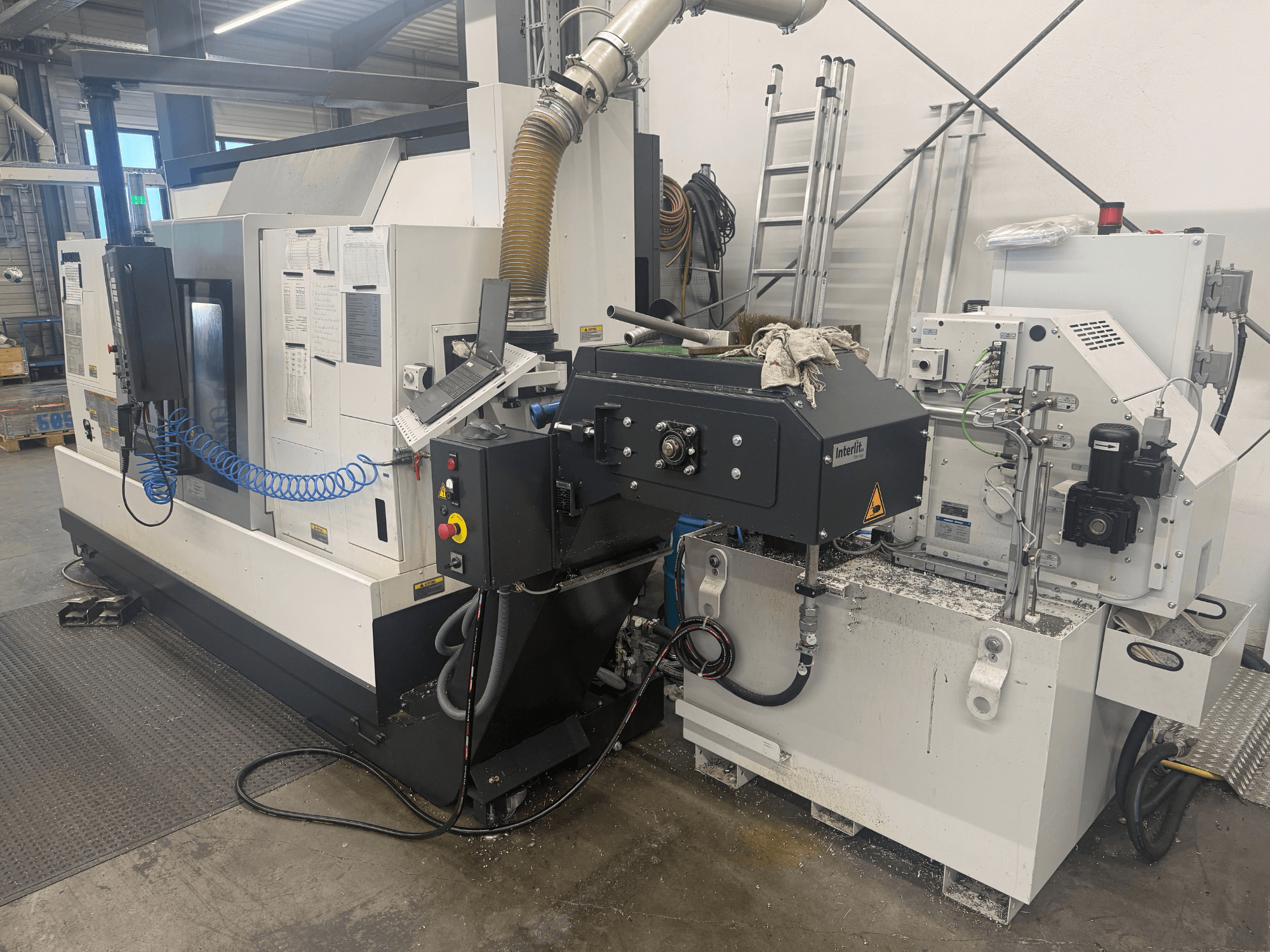 Okuma LB3000II-MYC 950 vízszintes esztergagép, elölnézet, a vezérlőpanel és a hűtőfolyadék-rendszer bemutatása.