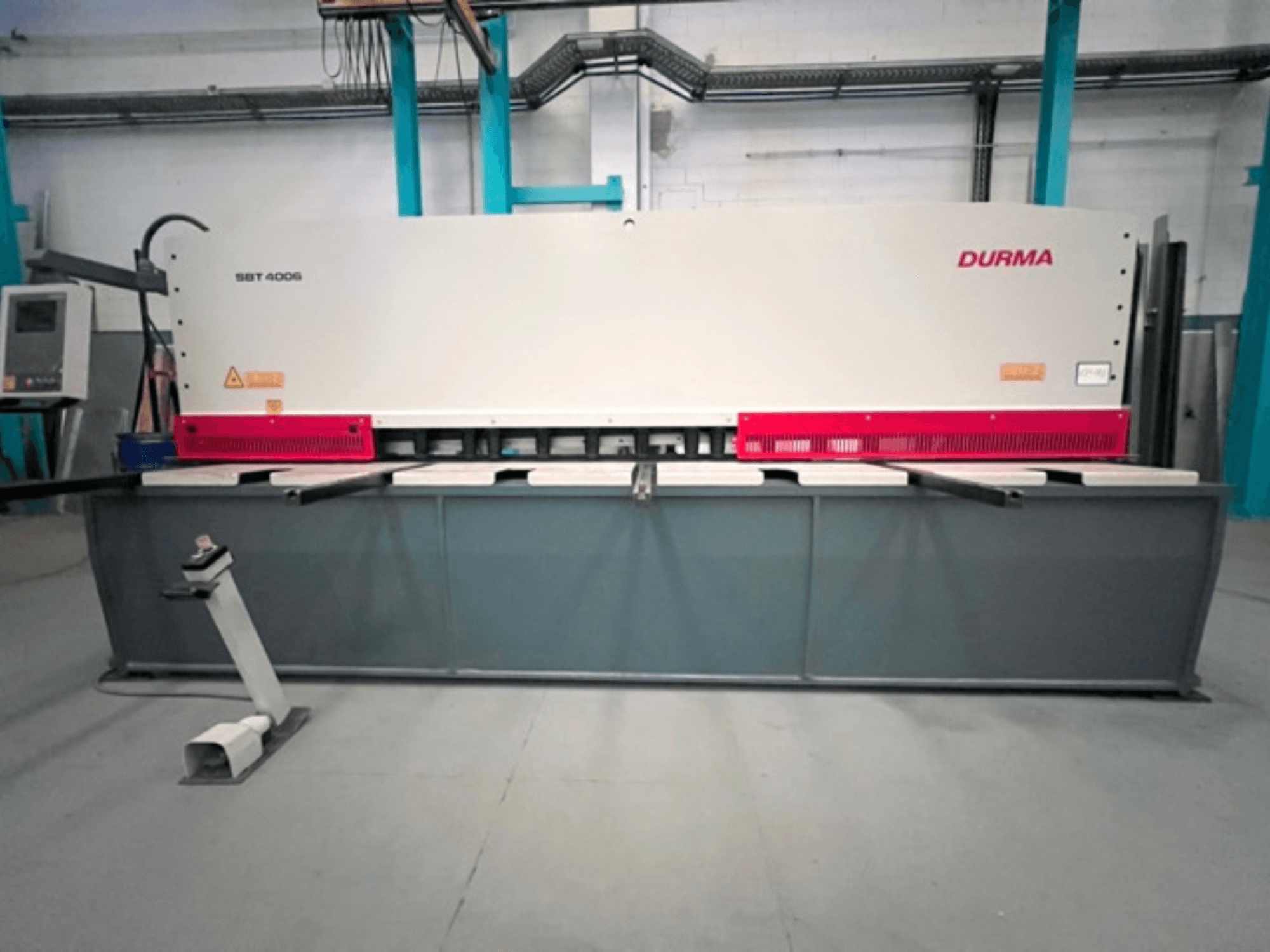 CNC nyírógép Durma SBT 4006 elölnézetben, szürke alapon és piros ékezetekkel, üzemkészen, gyári környezetben.