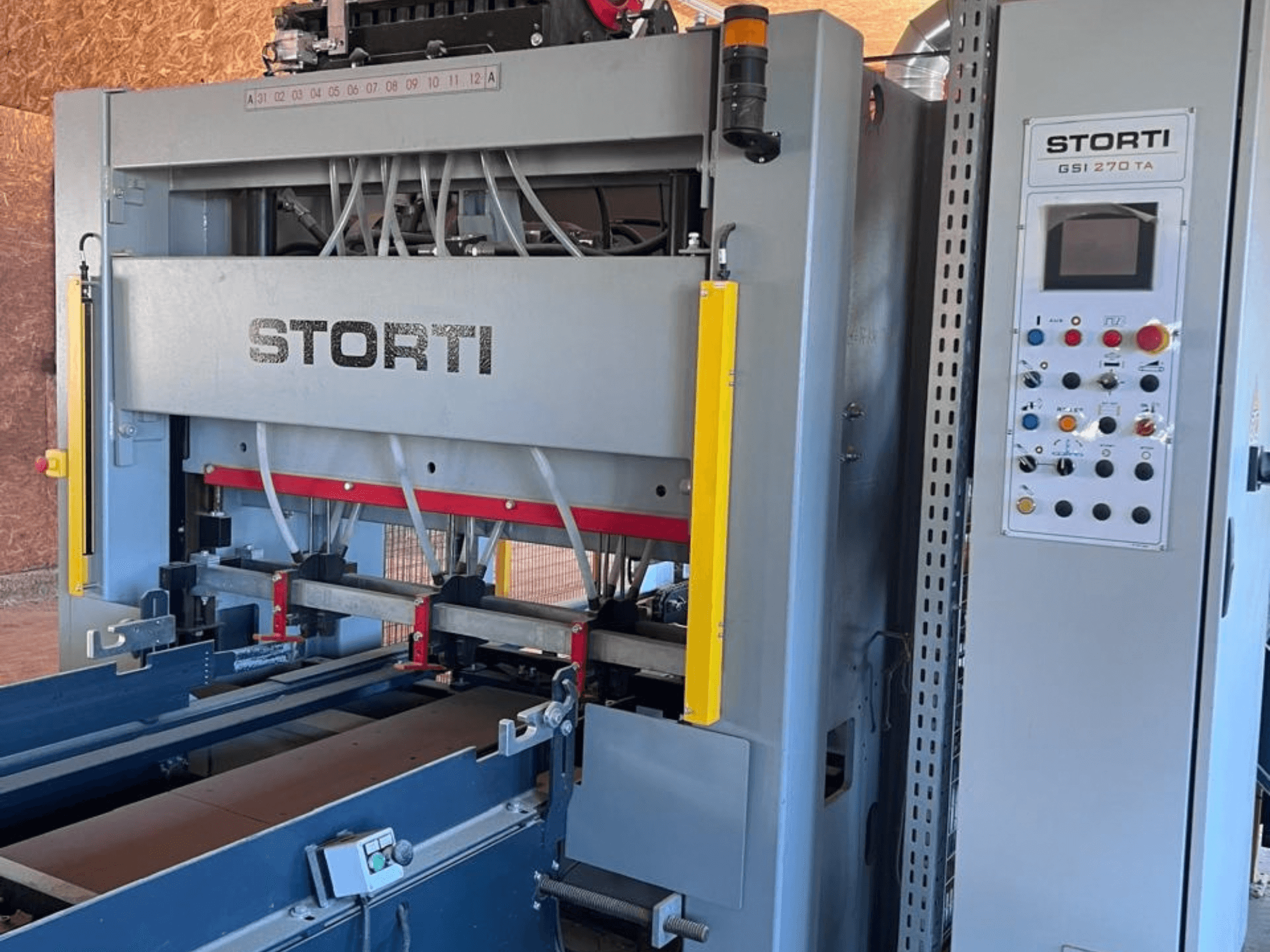 STORTI GSI 170-270 TA9 faipari gyártósor, elölnézet a vezérlőpanellel és a hidraulikus présmechanizmusokkal.
