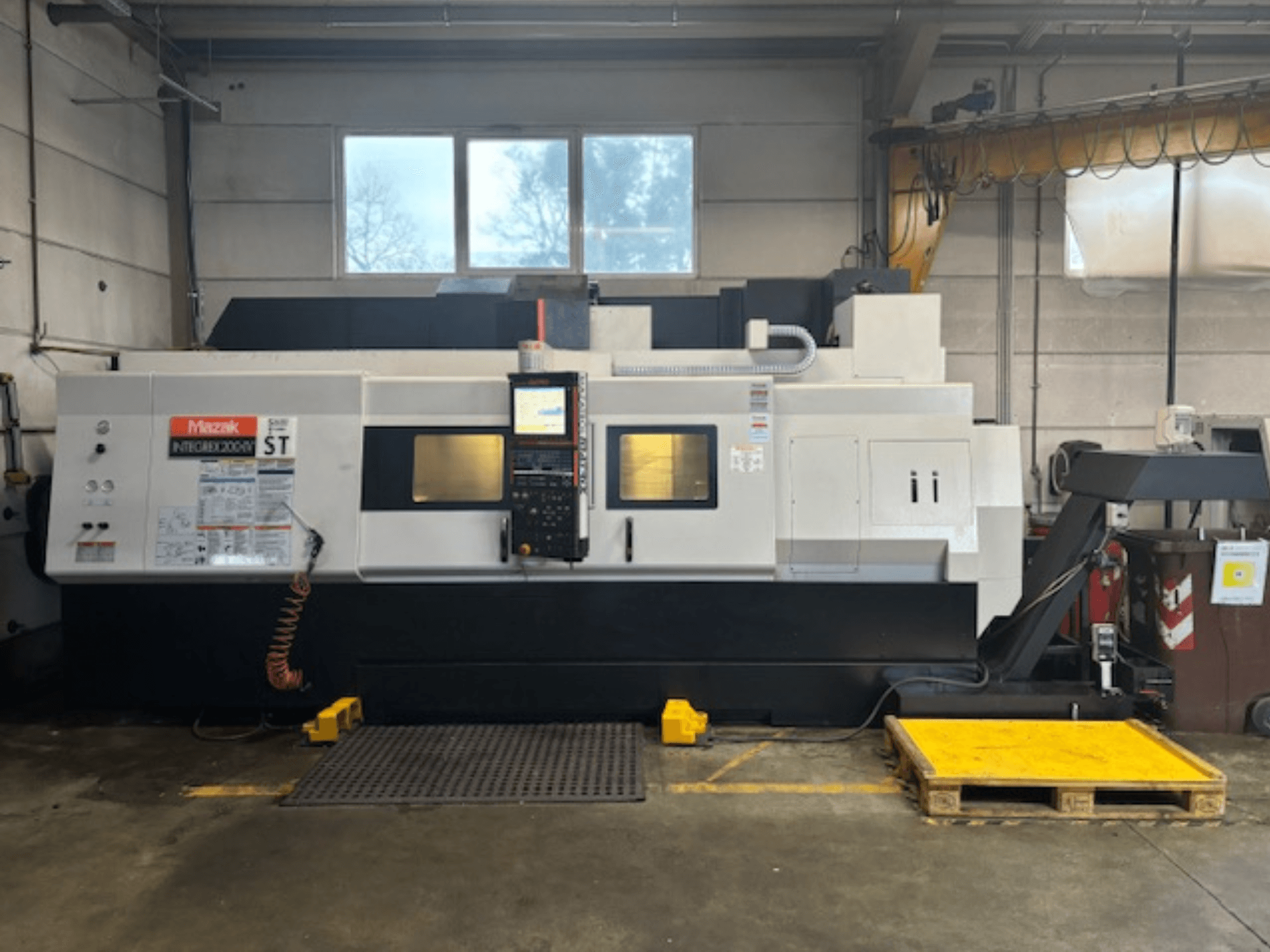 Mazak Integrex 200 SY ST, oldalnézet, a vezérlőpanel, a kezelőpanelek és a hűtőfolyadék-vezetékek műhelyben.