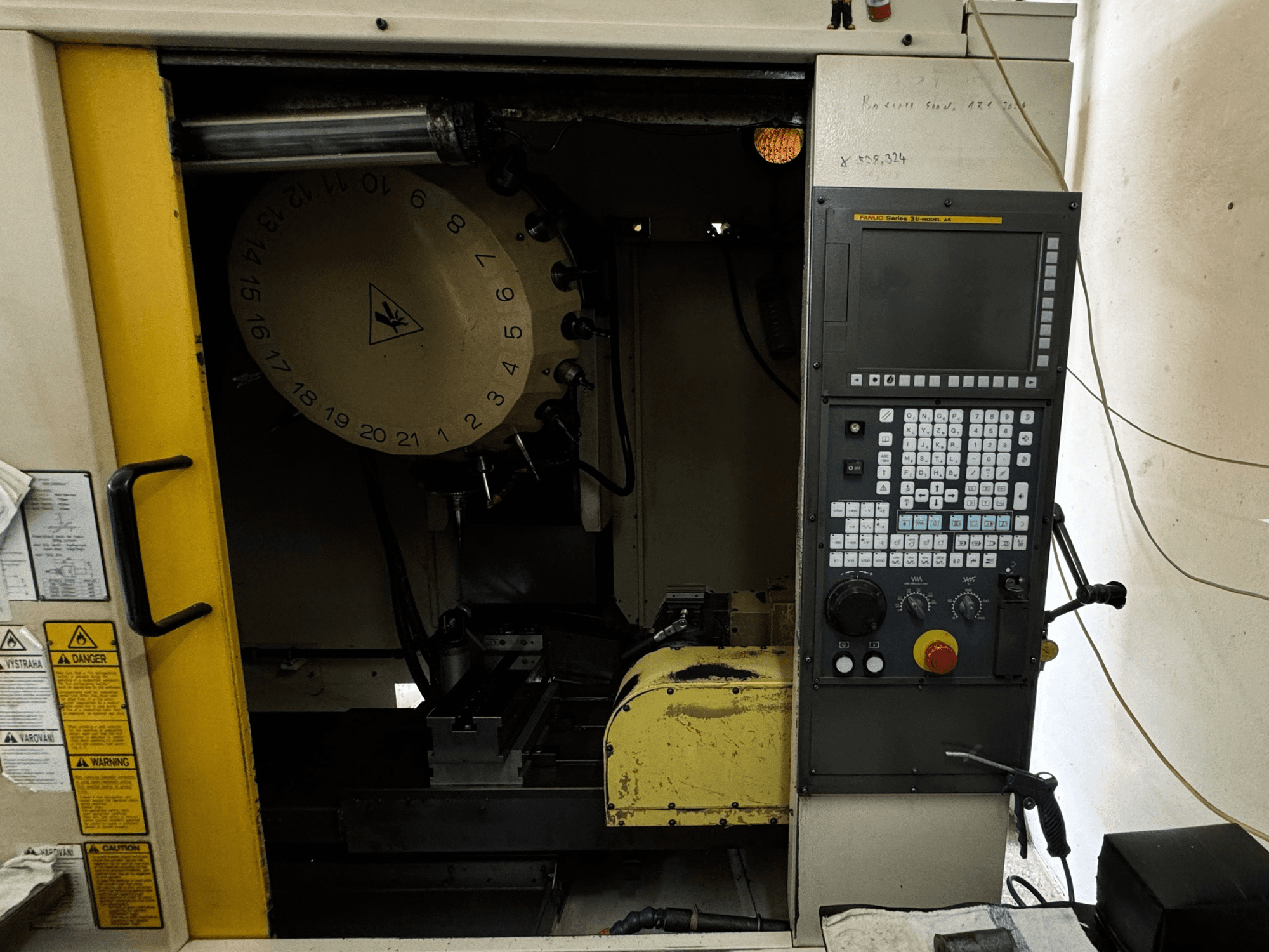 FANUC Robodrill alpha-T21iFL függőleges megmunkálóközpont, elölnézetben a vezérlőpanel és a szerszámtároló.