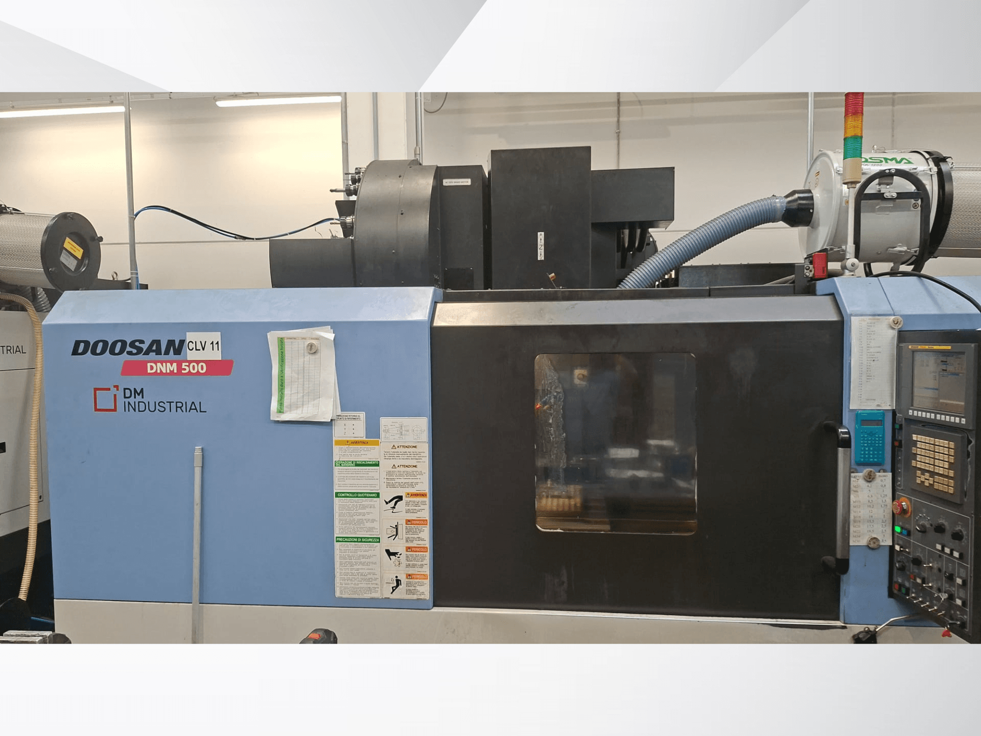 A DOOSAN DNM 500 függőleges megmunkálóközpont oldalnézete, a vezérlőpanellel és a működtető elemekkel.