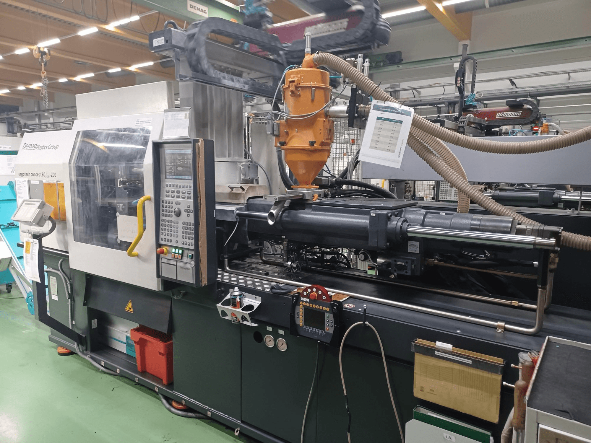 Demag Ergotech 200 fröccsöntőgép, elölnézet, a vezérlőpanel, a fúvóka és a működési alkatrészek láthatóak.