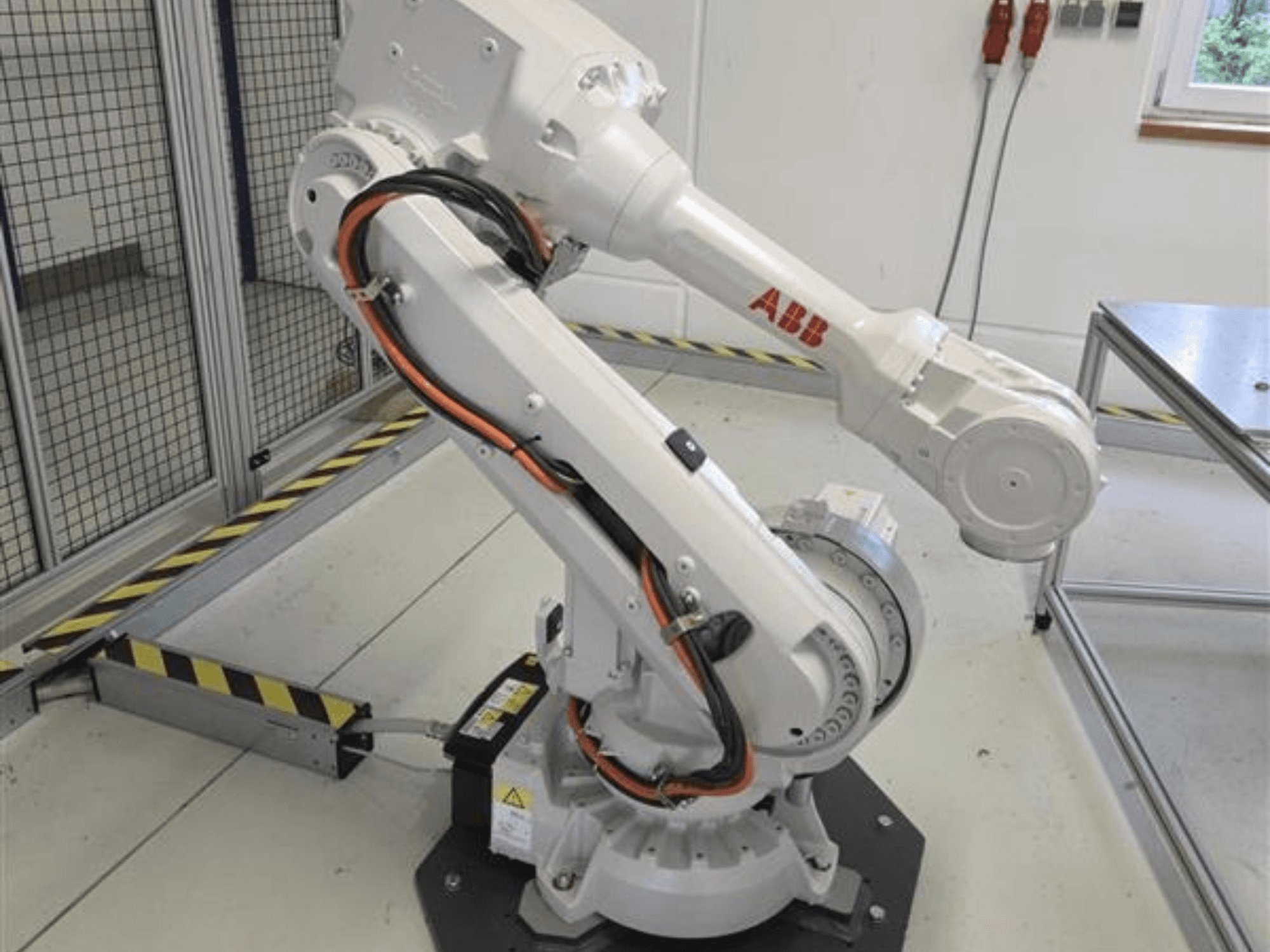 Az ABB IRB 4600-45/2.05 robotkar profilnézetben, amelyen jól látható a csuklós kialakítása és az alaphoz csatlakozó kábelek.