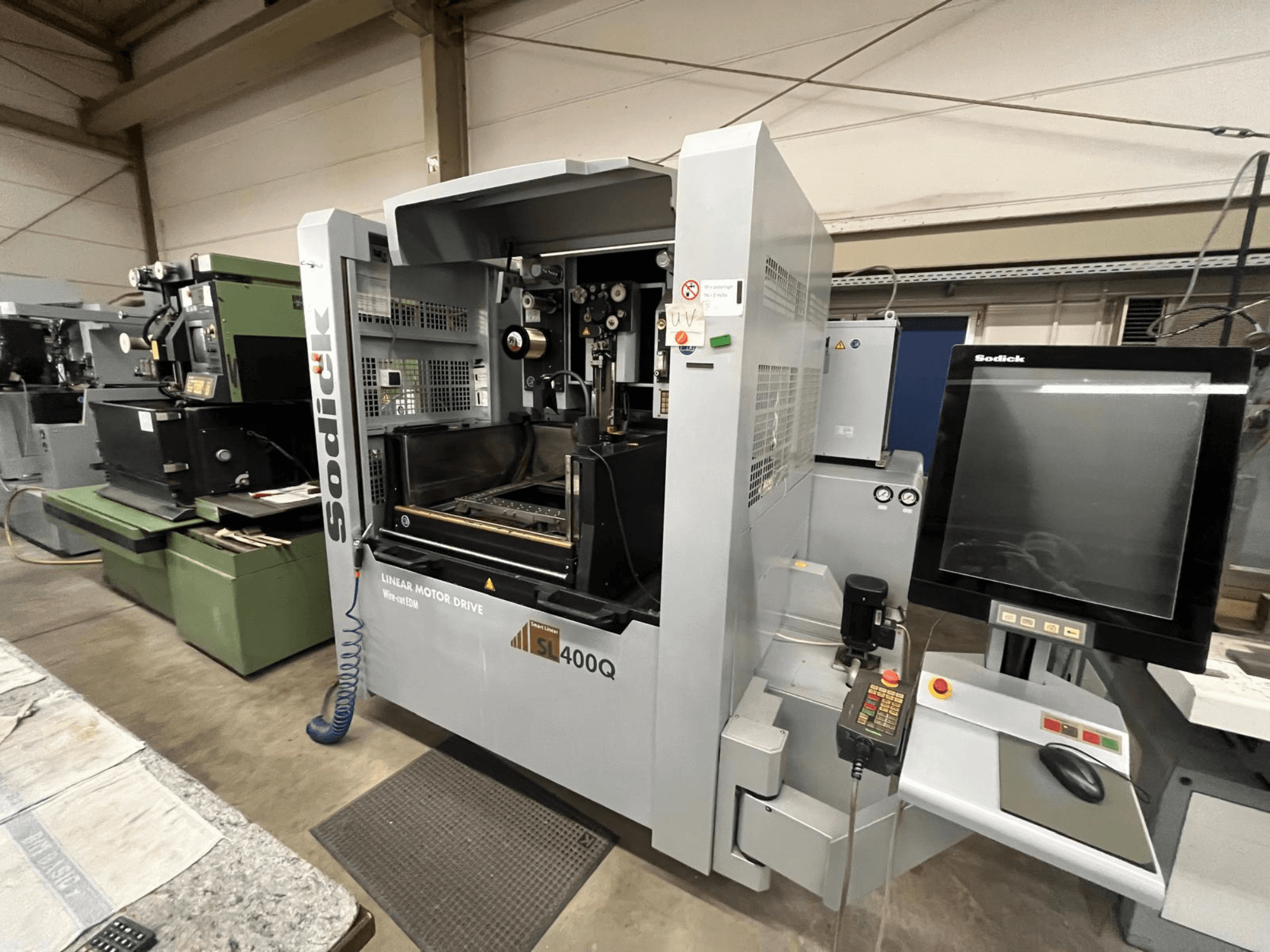 Sodick SL400Q lineáris motoros meghajtású CNC-gép, elölnézetben, digitális vezérlőpanel és kijelző műhelyben.