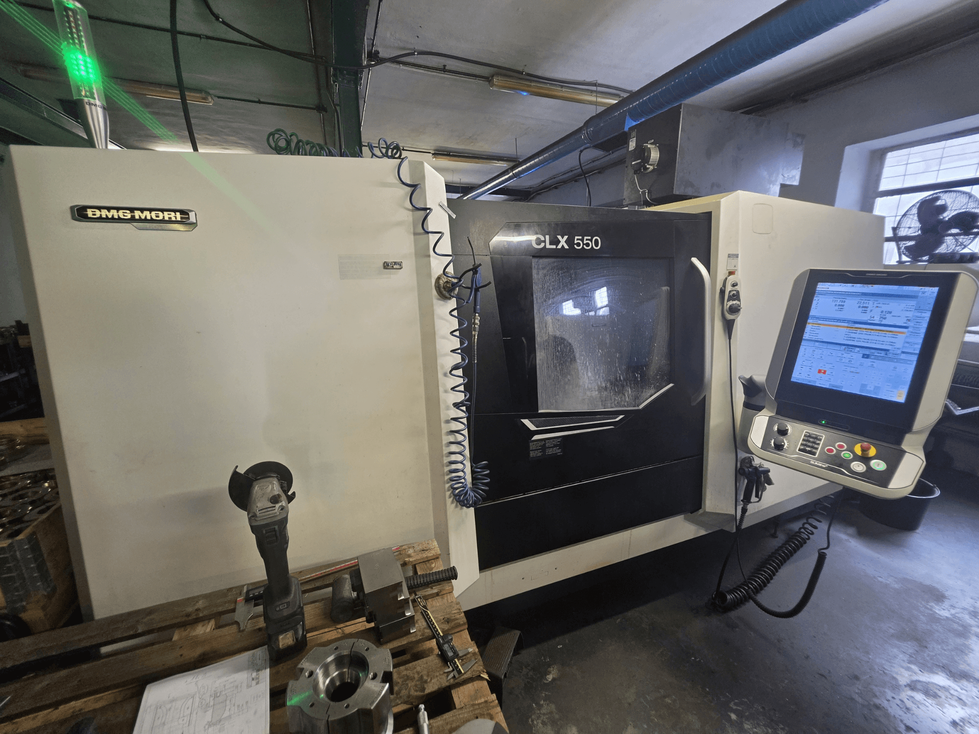 DMG MORI CLX 550 V3 vízszintes eszterga, elölnézet, amelyen látható a vezérlőpanel, a vágószerszámok és a gépház.