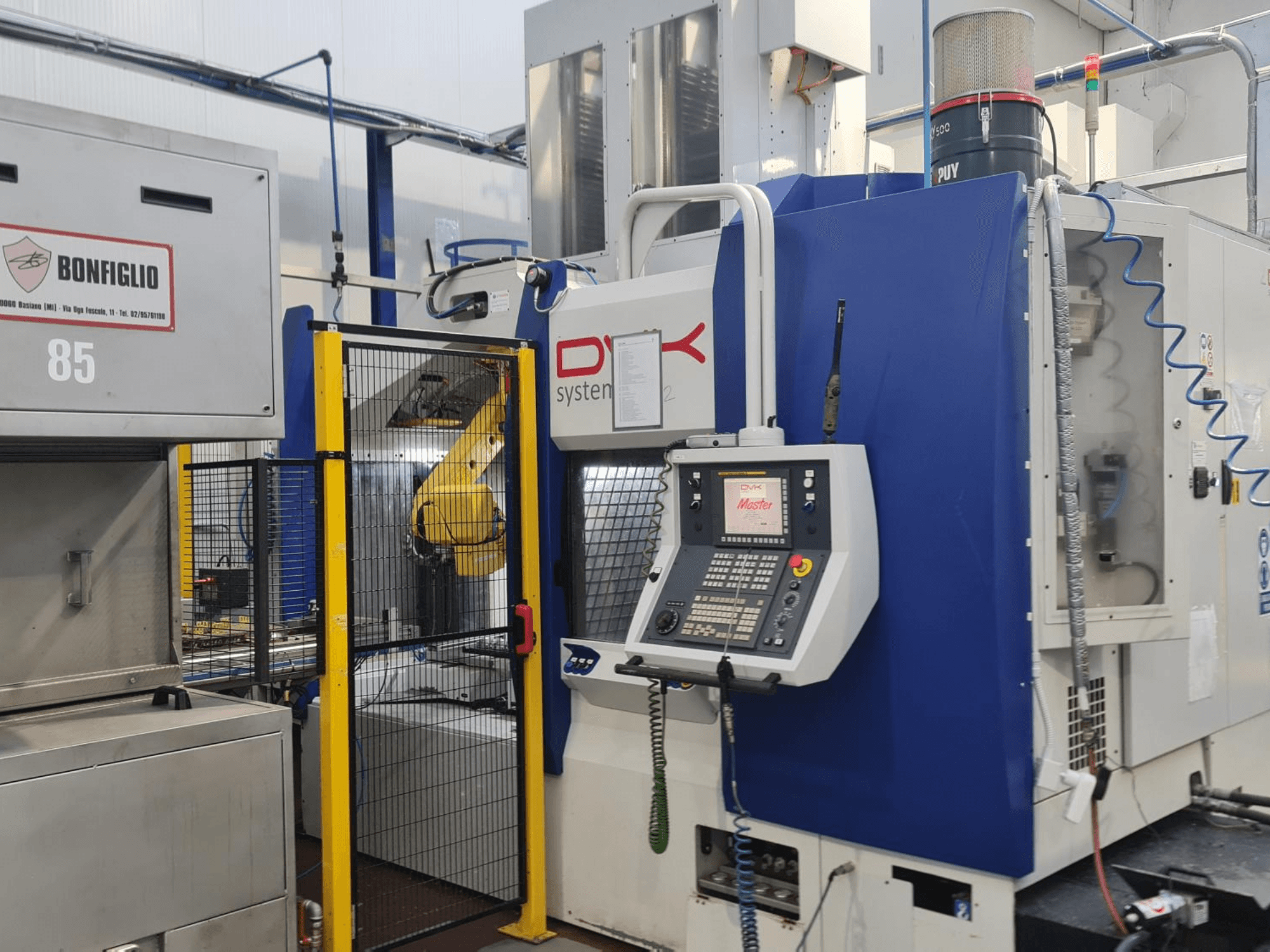 DVK System Master vízszintes megmunkáló központ, elölnézet, a vezérlőpanellel, a biztonsági kapuval és a robotkarral.
