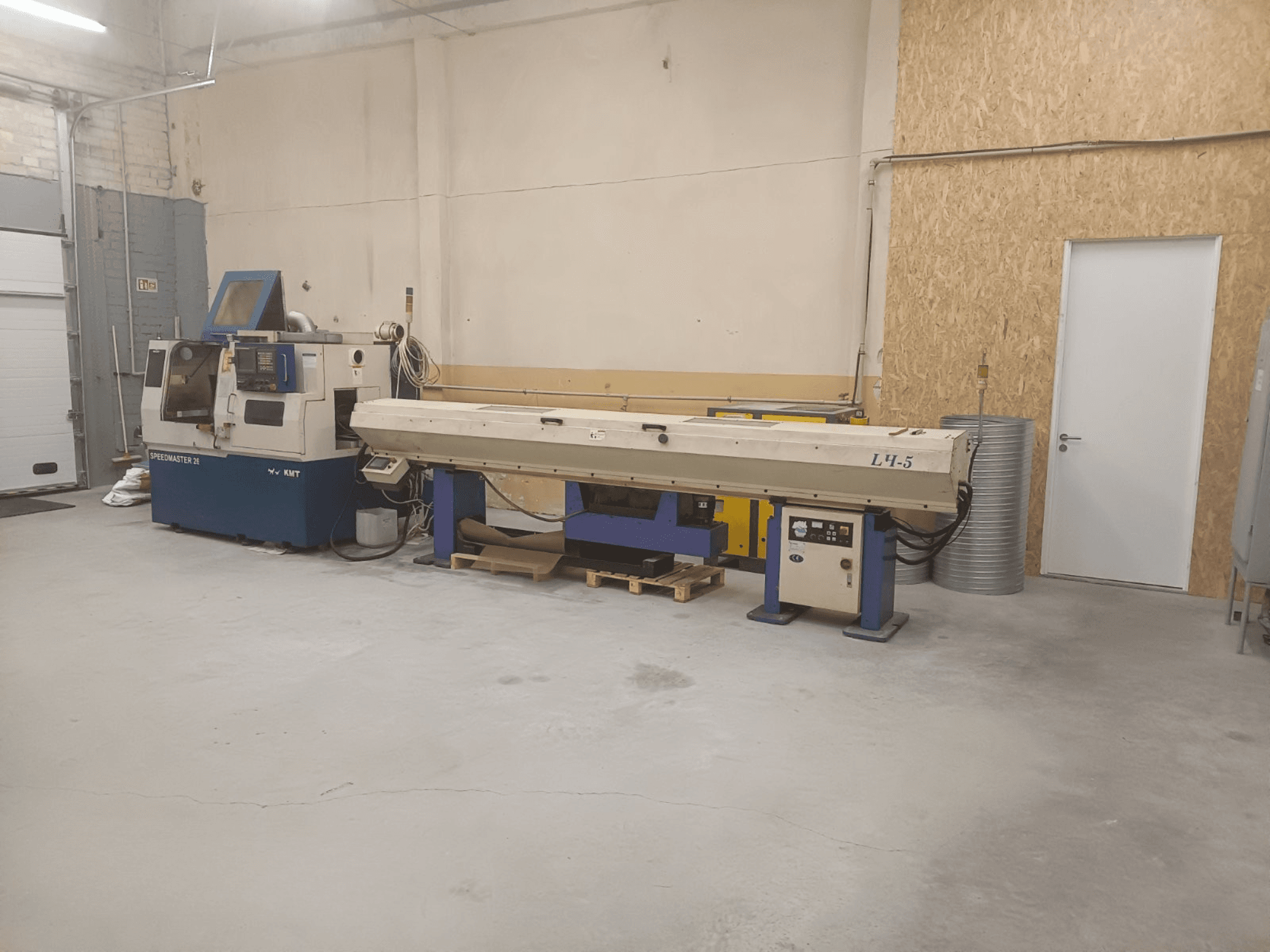 Ipari műhely a KMT Speedmaster 34 géppel és az L4.5 géppel, szemből nézve, látható vezérlőkkel és gépekkel.