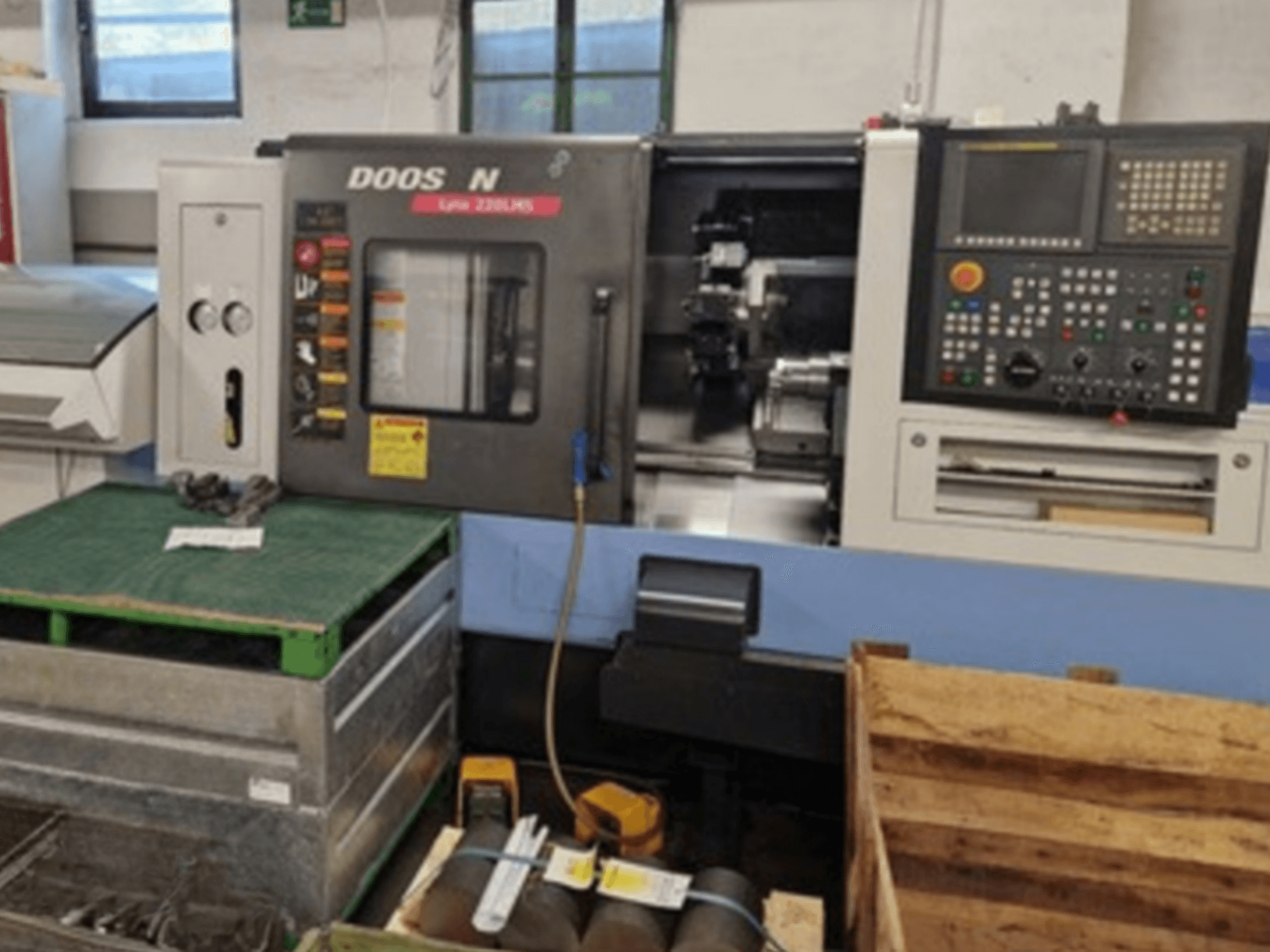 DOOSAN Lyax 220 LMS vízszintes esztergagép elölnézetben, a vezérlőpanel, a szerszámok és a munkaterület bemutatásával.