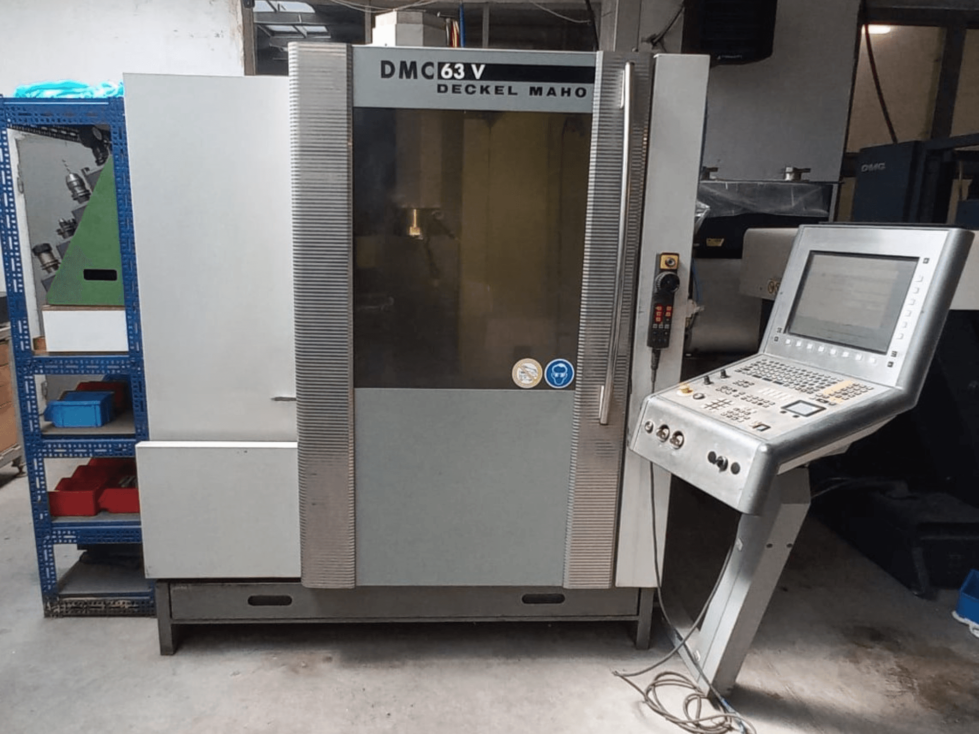 A DMG DECKEL MAHO DMC 63V függőleges megmunkáló központ elölnézete, a vezérlőpanellel és a látható munkaterülettel.