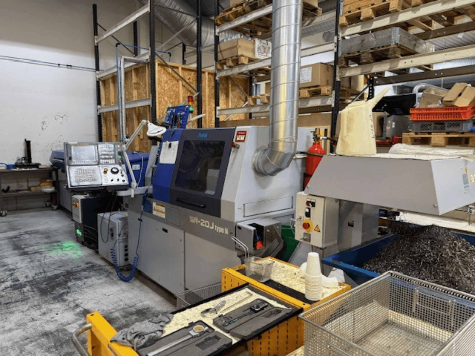 Egy Faroh SPR-20J típusú N megmunkálóközpont előlnézetben, vezérlőpanellel, fémforgácsokkal és biztonsági berendezésekkel egy műhelyben.