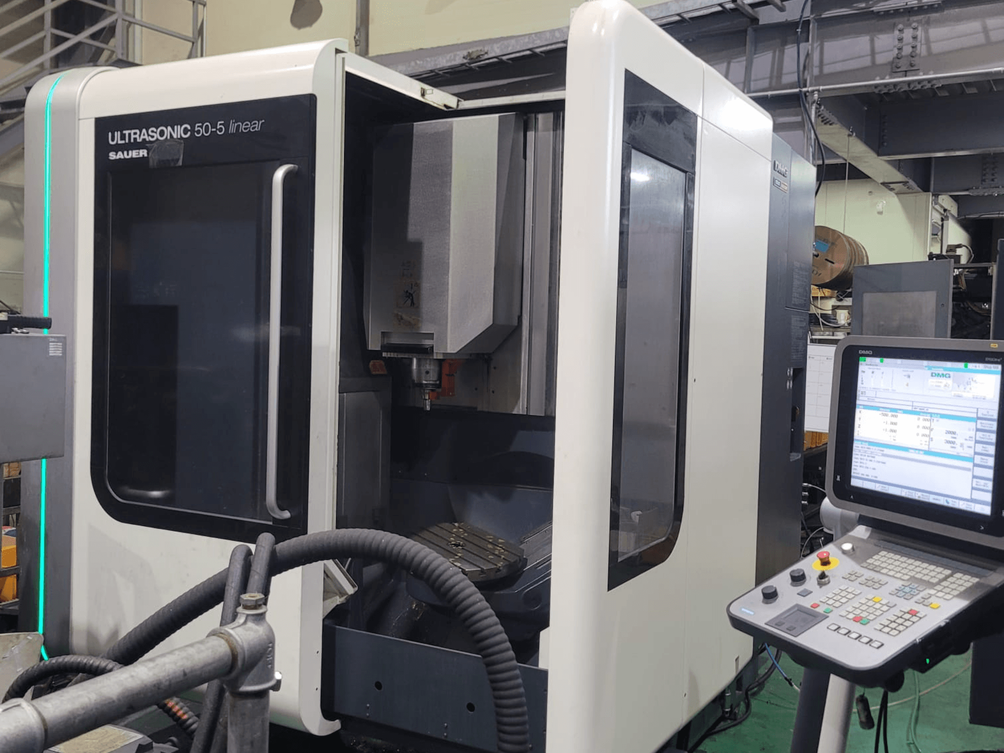 DMG ULTRASONIC 50-5 lineáris univerzális megmunkálóközpont, elölnézet a kezelőpanellel és a látható munkaterülettel.