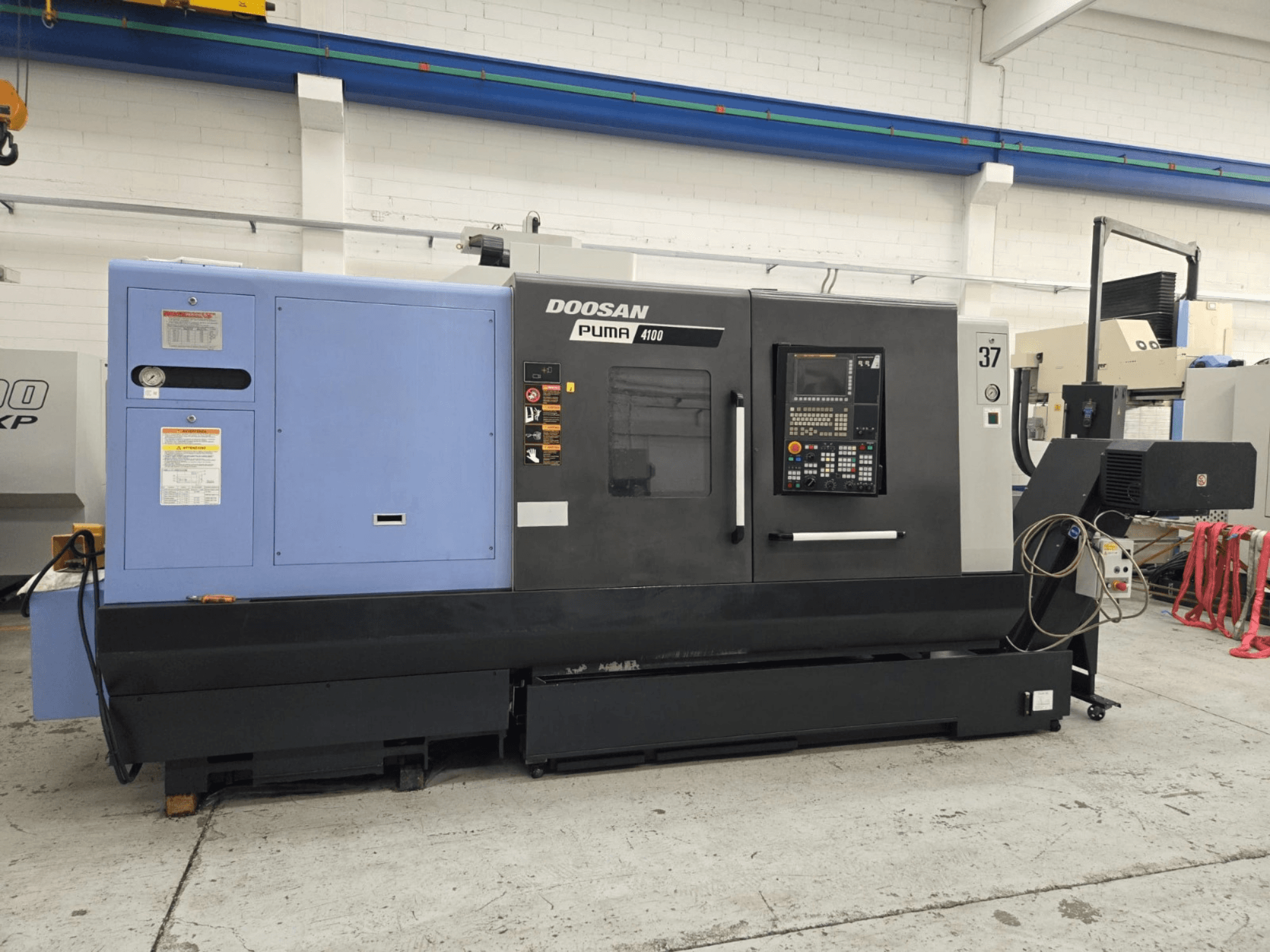 Doosan Puma 4100 CNC eszterga, előlnézet; vezérlőpanel, kék erőforrás és részletes címkék a kezelési útmutatóhoz.