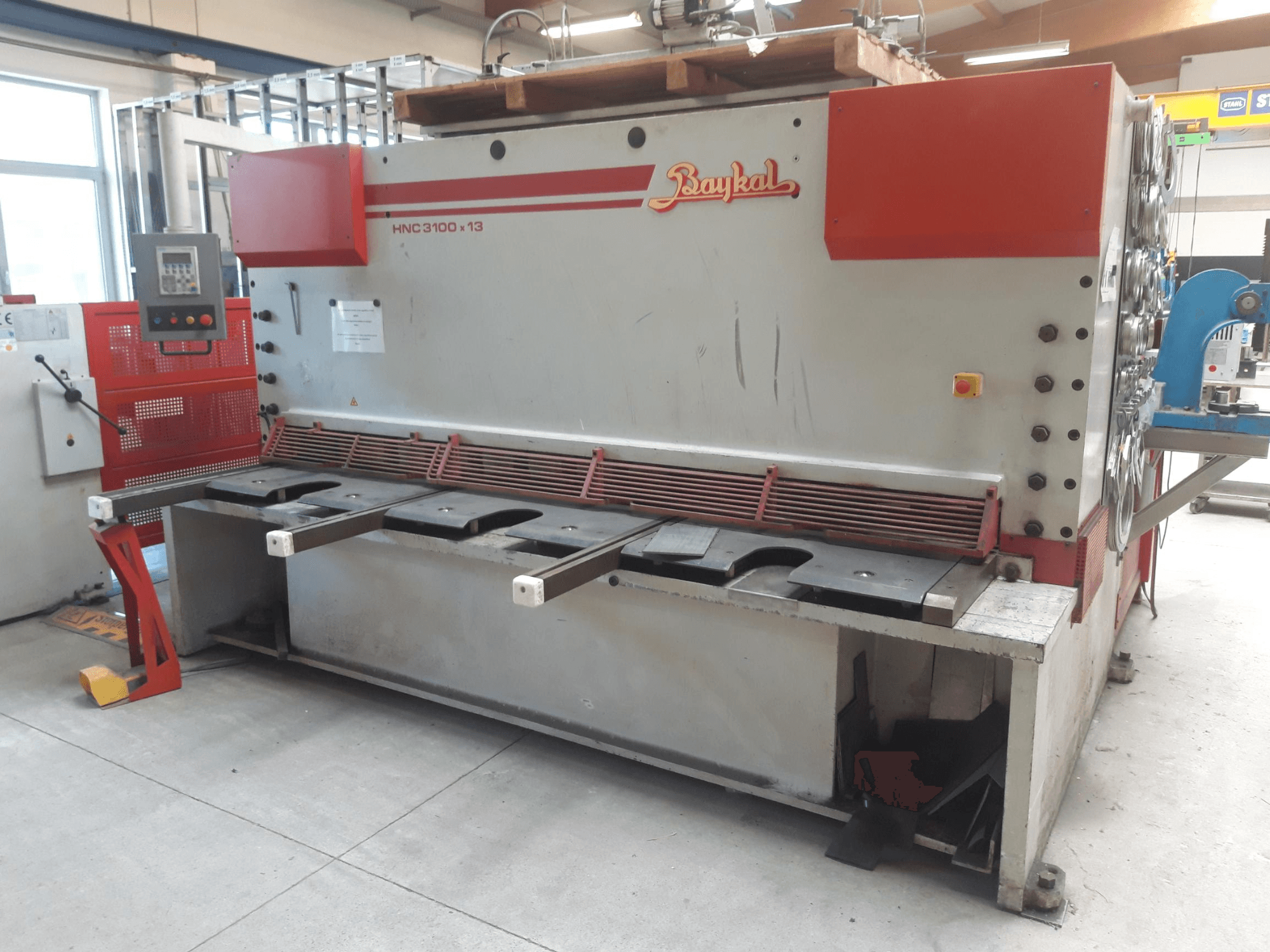 A Baykal HNC 3100x13 CNC-vágógép elölnézete, amelyen látható a vezérlőpanel, a fémvágási terület és a hulladékgyűjtő rekesz.