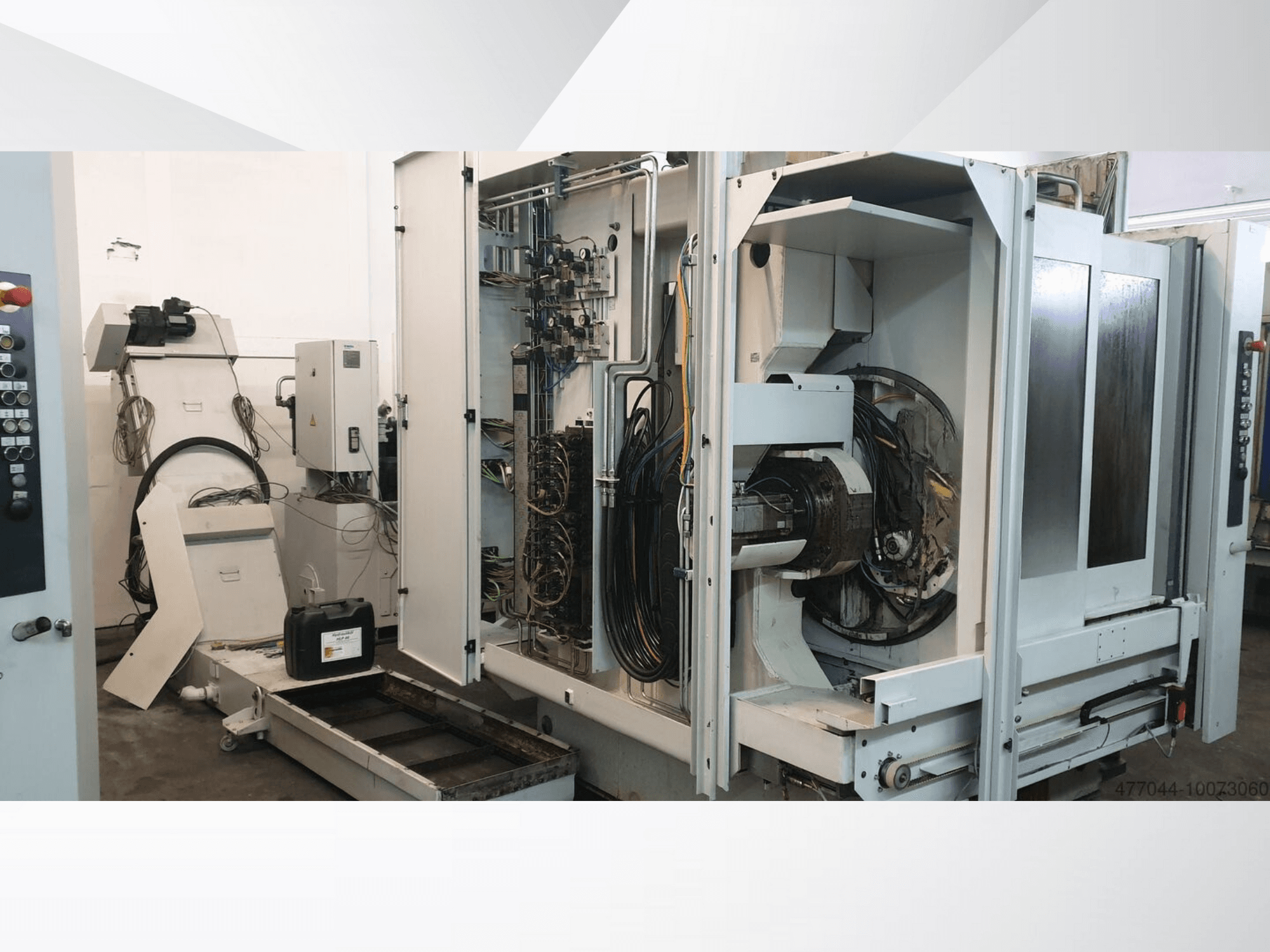 Ipari gépek, amelyeken látható vezetékek, vezérlőpanel és mechanikus alkatrészek vannak; egy összetett gép oldalnézetből.