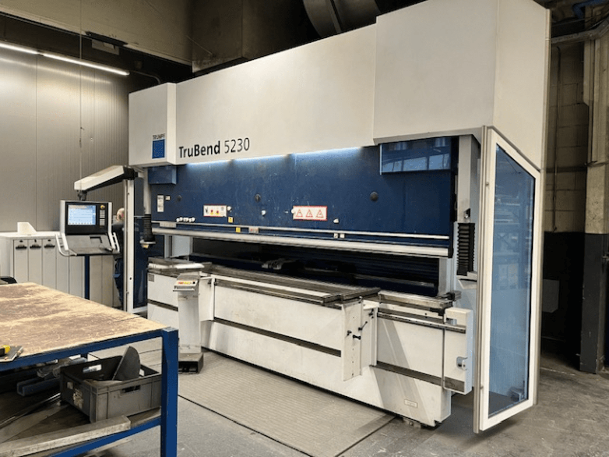 TruBend 5230 hajlítógép ipari környezetben; elölnézetben a vezérlőpanel, a biztonsági berendezések és a munkaasztal.