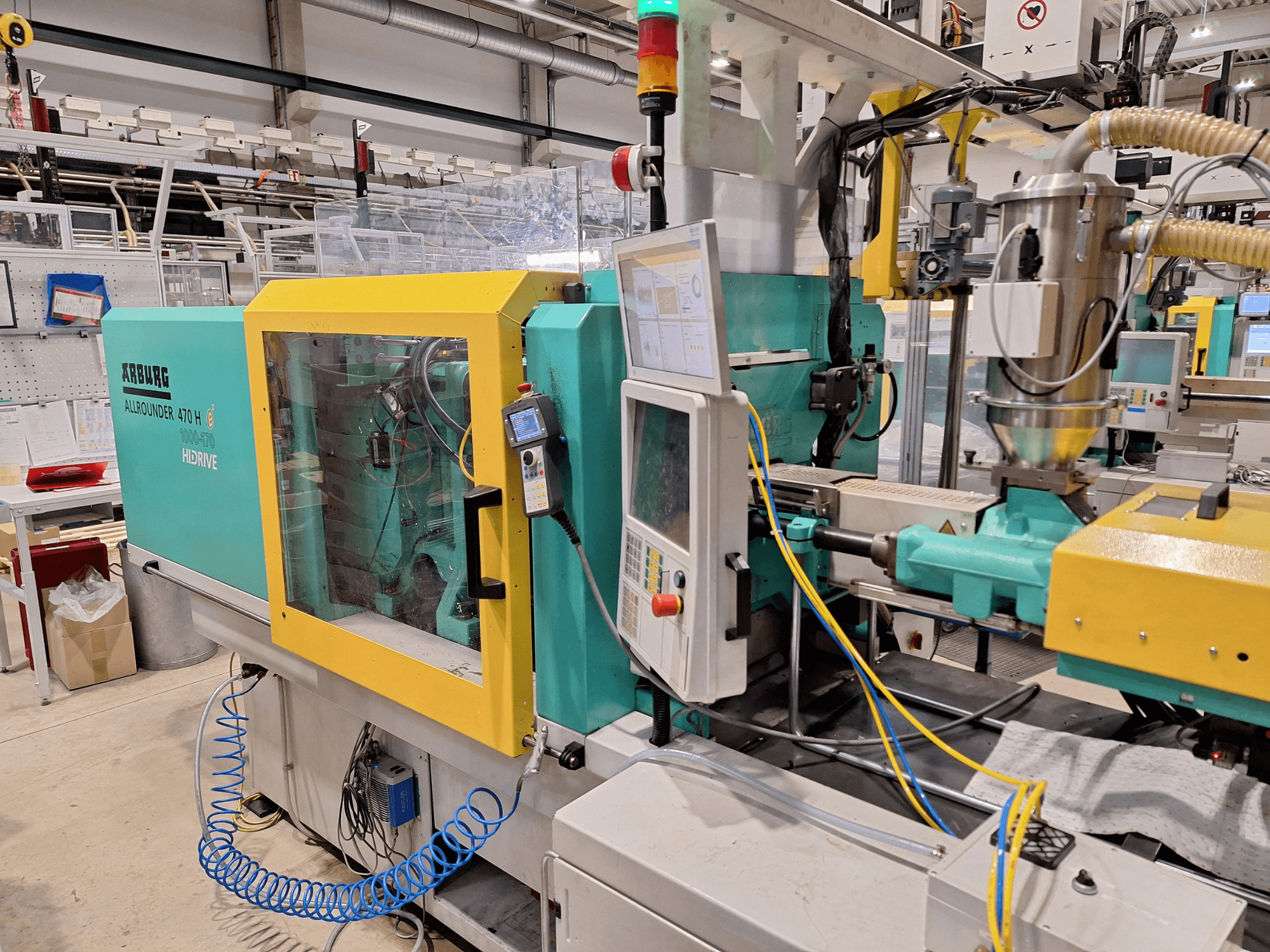 Arburg 470 H 1000-170 hidraulikus fröccsöntőgép, oldalnézetben a vezérlőpanel és az adagolórendszer.