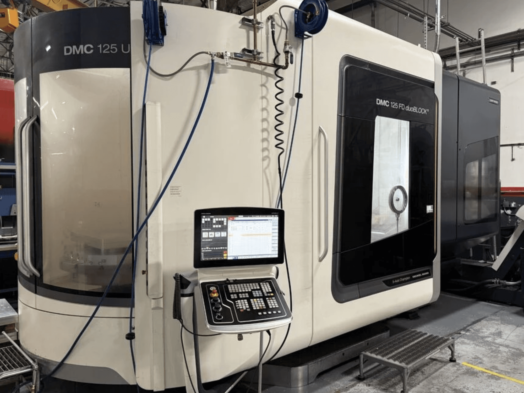 DMG MORI DMC 125 U duoBLOCK univerzális megmunkáló központ, elölnézet a kezelőpanellel és a fényvisszaverő felületekkel.