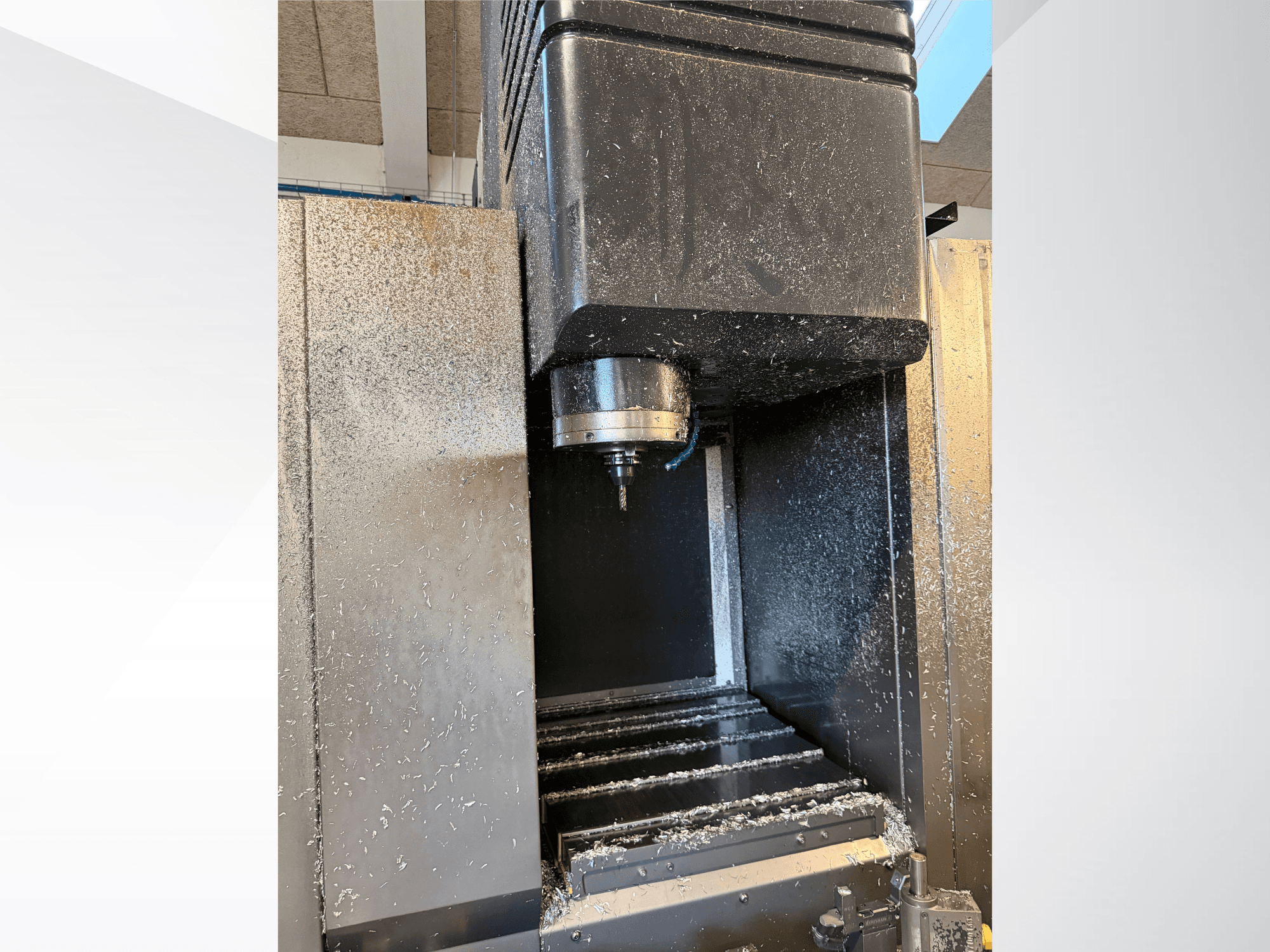 Mazak VTC 300C II függőleges megmunkáló központ, elölnézet, amelyen látható az orsó és a megmunkálás során keletkező forgácsok.