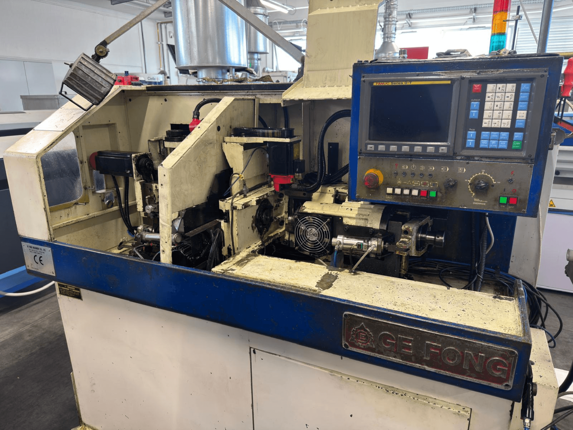 GE FONG ipari gép elölnézetben, a belső alkatrészek, a vezérlőpanel és a működő alkatrészek bemutatásával.