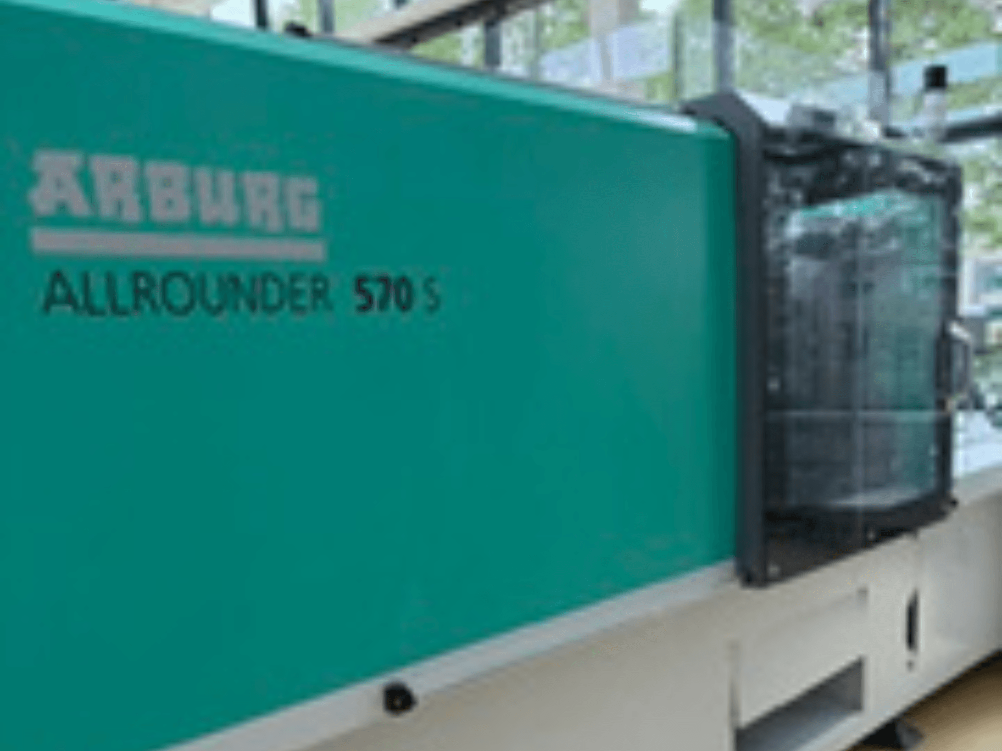 Az Arburg ALLROUNDER 570 S 1600-290 elülső nézete, amely a gép kialakításának egy részét mutatja a teáskék külsővel és a befecskendező egységgel.