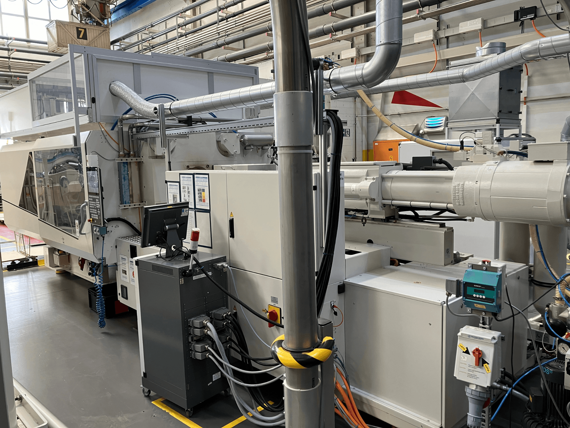 Ipari gép vezérlőpanellel, elölnézetben, csövekkel, elektromos alkatrészekkel és biztonsági berendezésekkel.