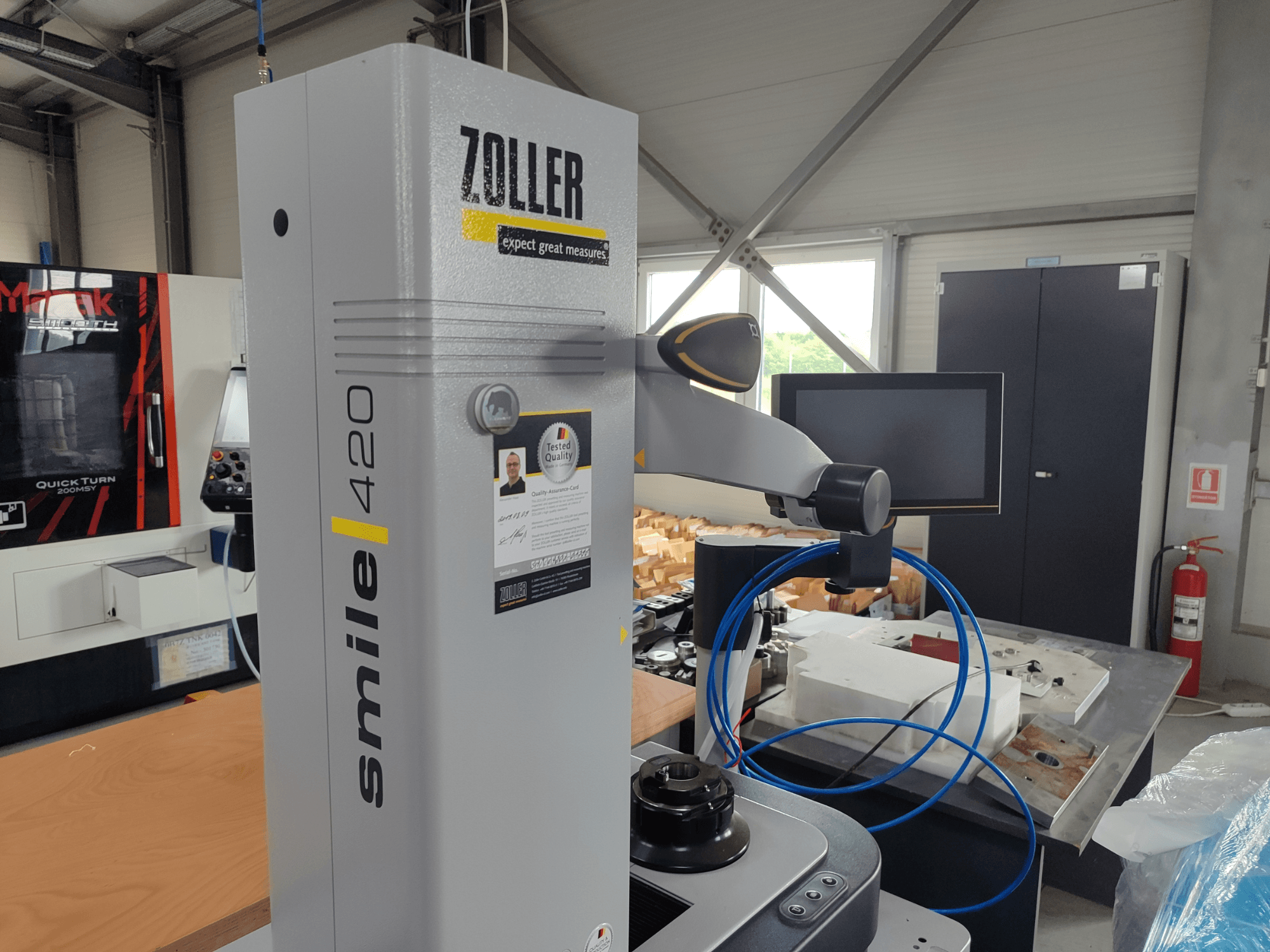 ZOLLER smile 420 mérőműszer monitorral, oldalnézet műhelyben, háttérben kék tömlők és gépek.