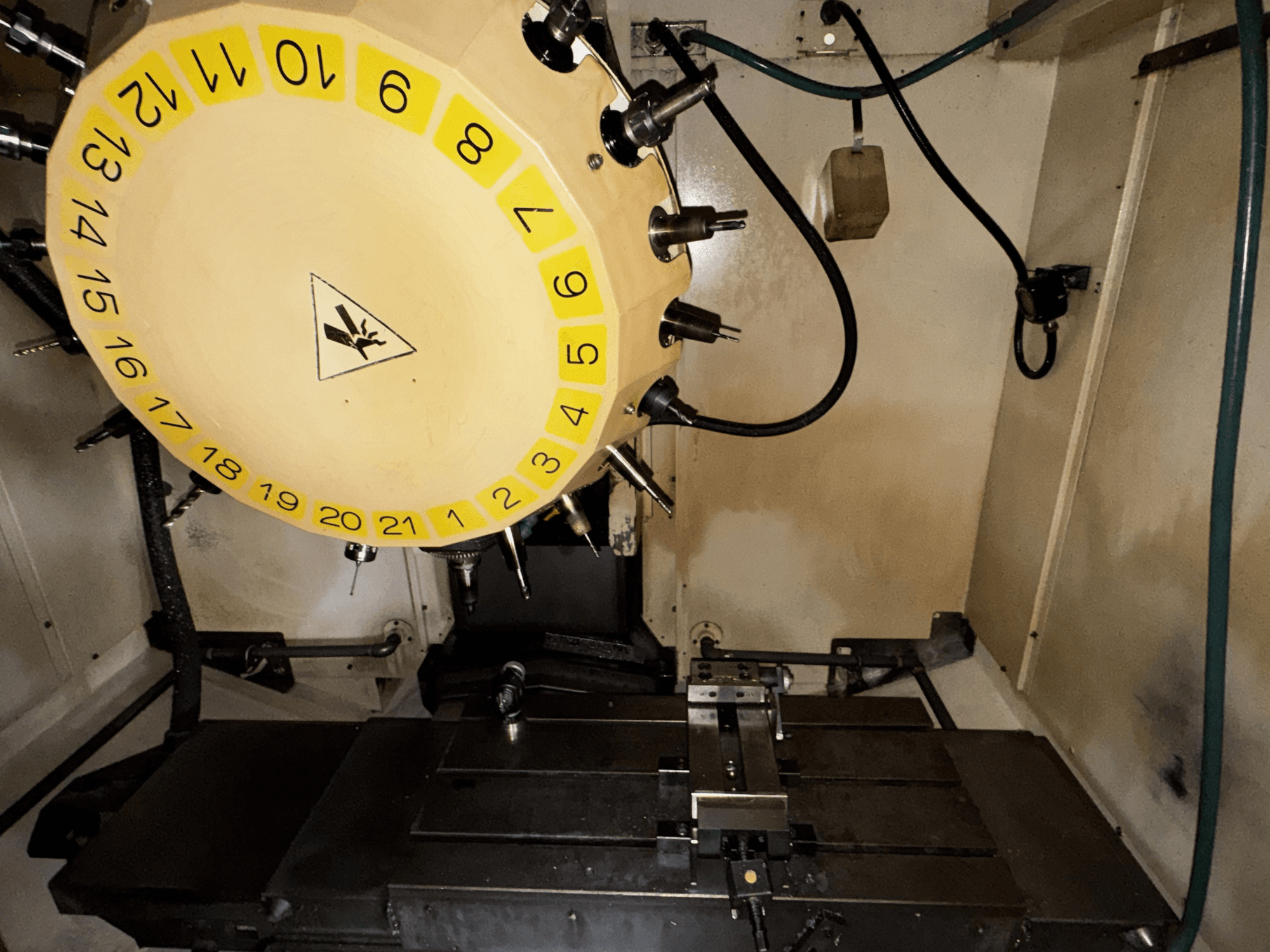 FANUC Robodrill alpha-T21iFL függőleges megmunkálóközpont belső nézete a szerszámkarusszellel és a megmunkálóasztallal.