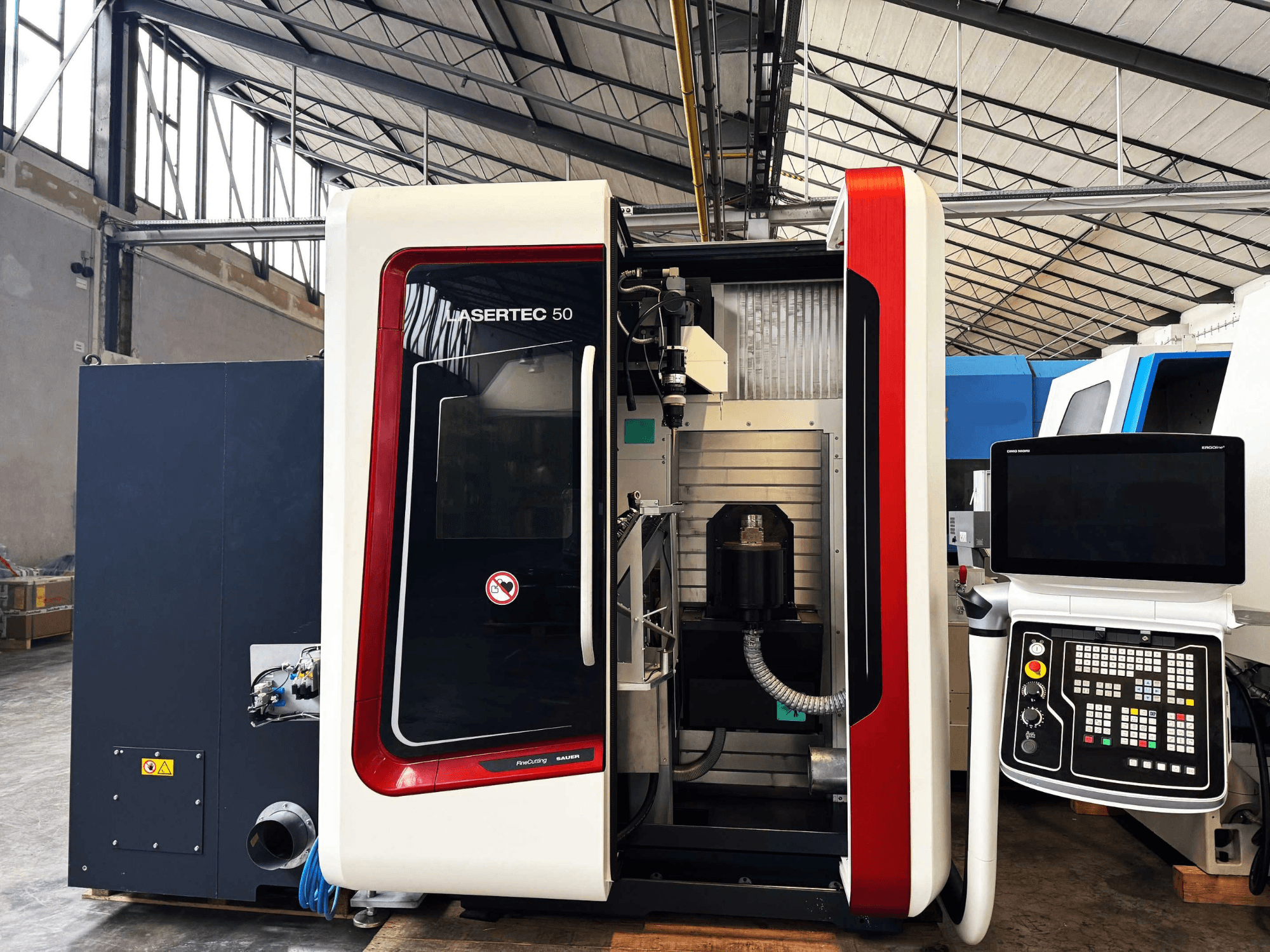 LaserTec 50 CNC gép oldalnézetben, fekete-fehér vezérlőpanel, látható szerszámtartó és ipari beállítás.