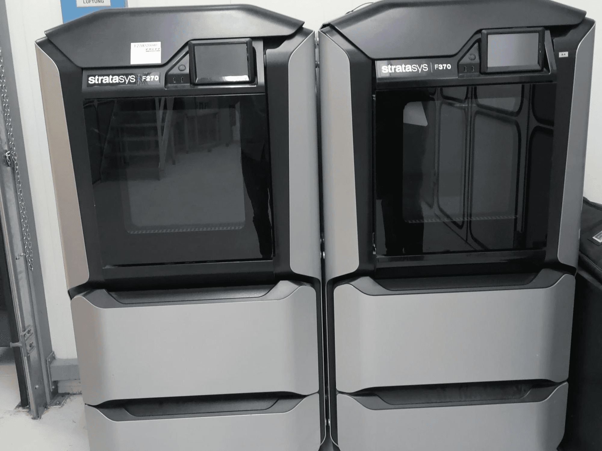 Stratasys F270 műanyag 3D nyomtató előlnézetben, kettős gép, elegáns szürke külsővel és digitális kijelzővel.