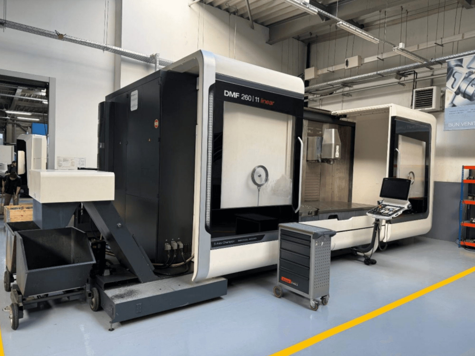 DMG MORI DMF 260 lineáris marógép szemből, a szerszámvezérlő panellel és egy mobil szerszámkocsival a közelben.