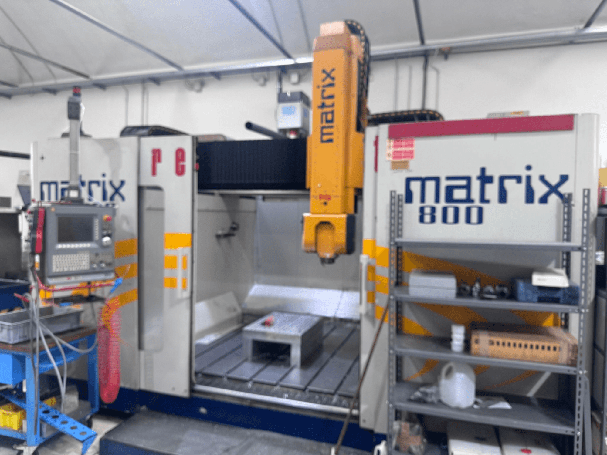 Matrix 800 CNC-gép műhelynézetben, vezérlőpanel, szerszámok és munkaasztal különböző tárgyakkal.