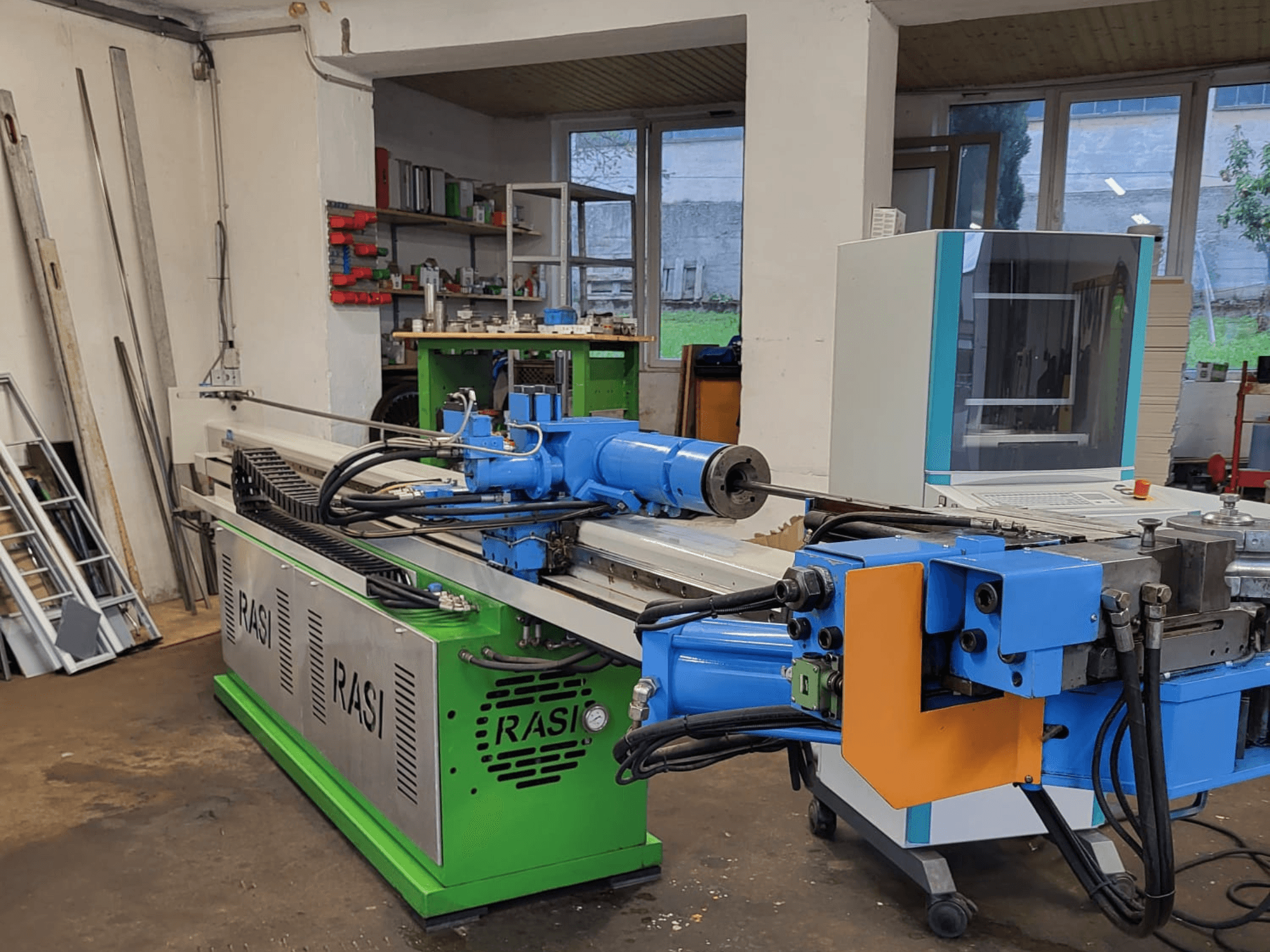 Rasi S 80.6 L G-V3C50 szerszámgép műhelyben, oldalnézetben a kék és zöld alkatrészek és a vezérlőpanel.