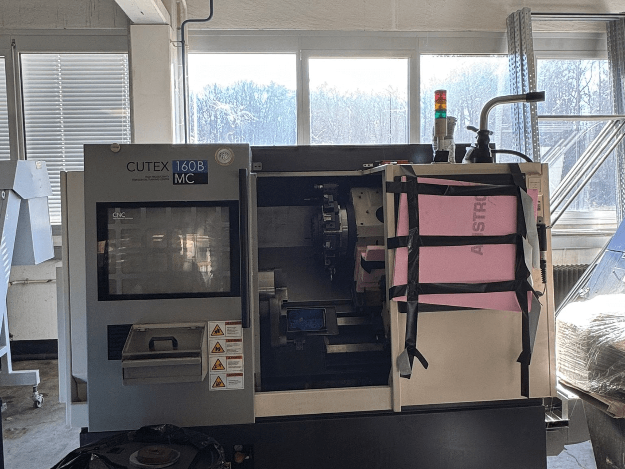 A HWACHEON CUTEX 160 B VDI vízszintes esztergagép elölnézete a vezérlőpanellel és a hűtőfolyadék-tartállyal, biztonsági lámpával ellátva.