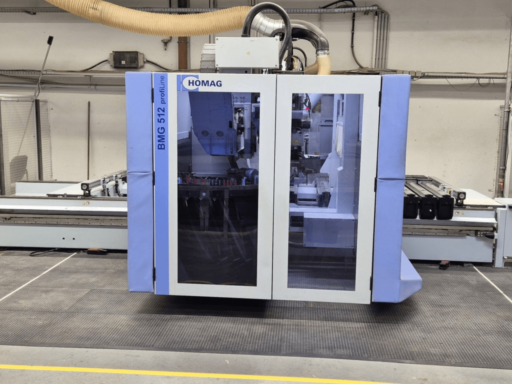 HOMAG BMG 512 ProfiLine CNC-gép, elölnézet, üvegpanel, látható precíziós szerszámok és ipari beállítások.