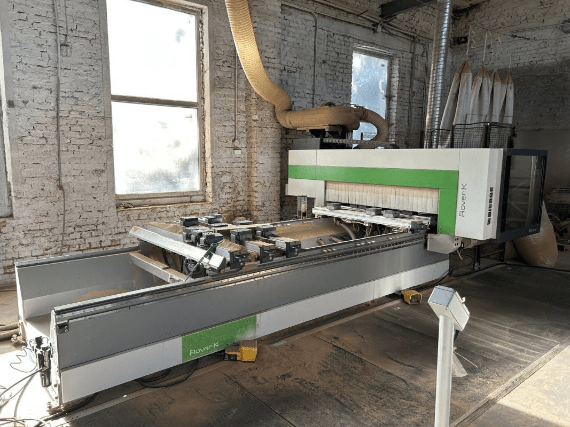 BIESSE Rover K 1532 G CNC megmunkálóközpont egy műhelyben, elölről nézve, a vágószerszámokkal és a munkapulttal.