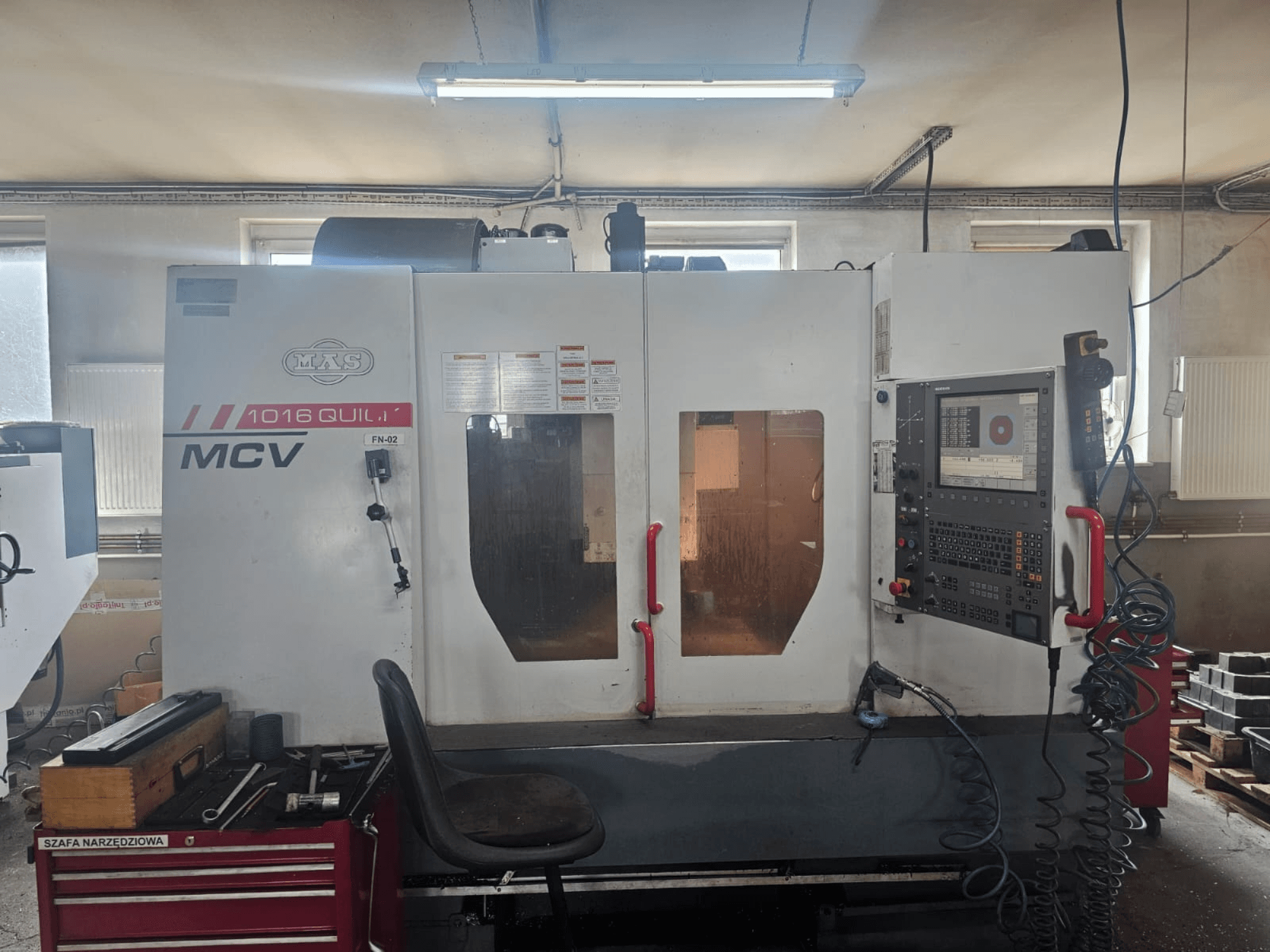 MVS MCV 1016 QUILL CNC-gép, előlnézet, vezérlőpanel, szerszámos fiók és szerszámokkal ellátott munkaterület.