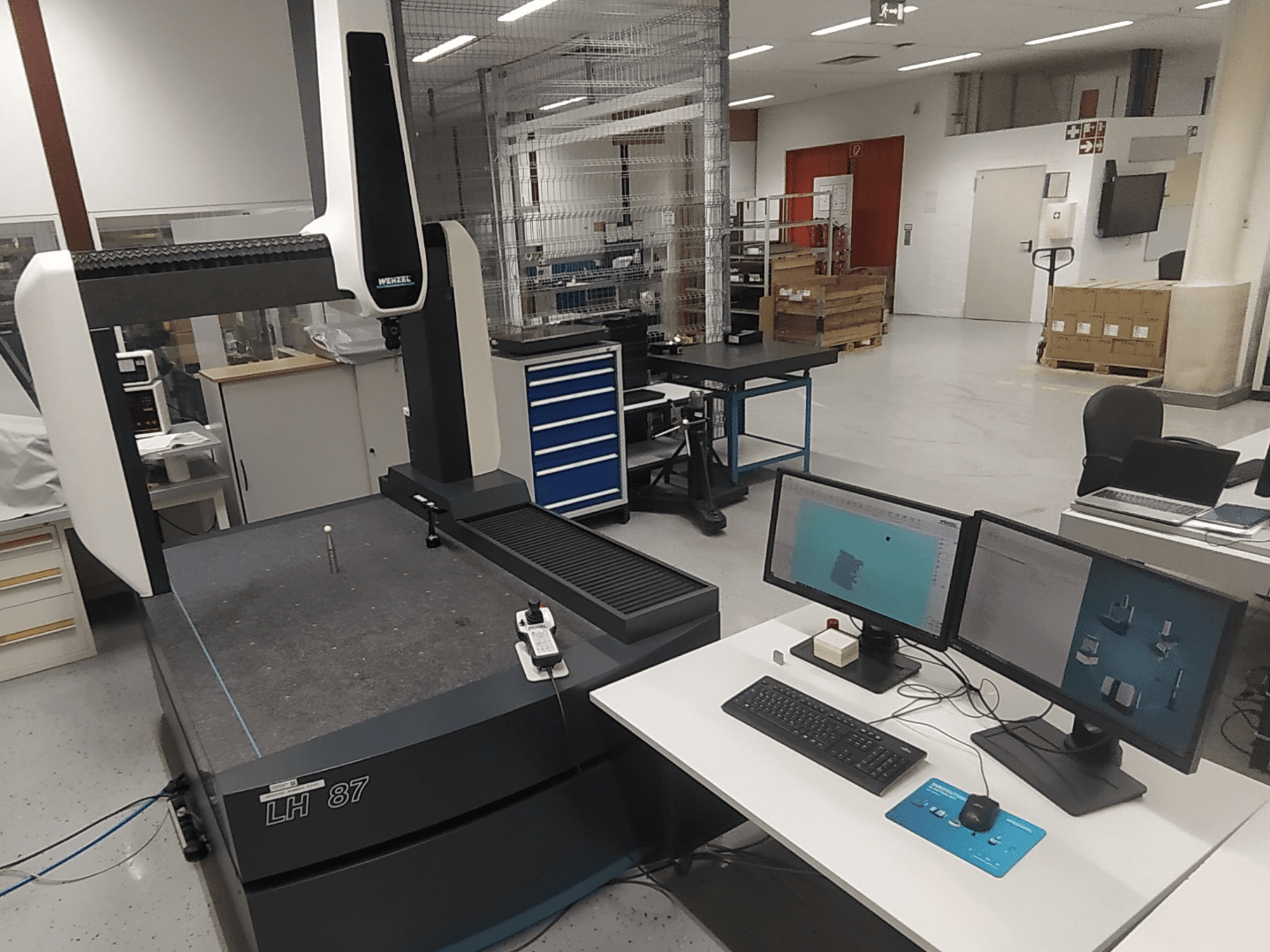 Wenzel LH 87 koordináta mérőgép látható laboratóriumi környezetben, kettős monitorral és mérőszondával az asztalon.