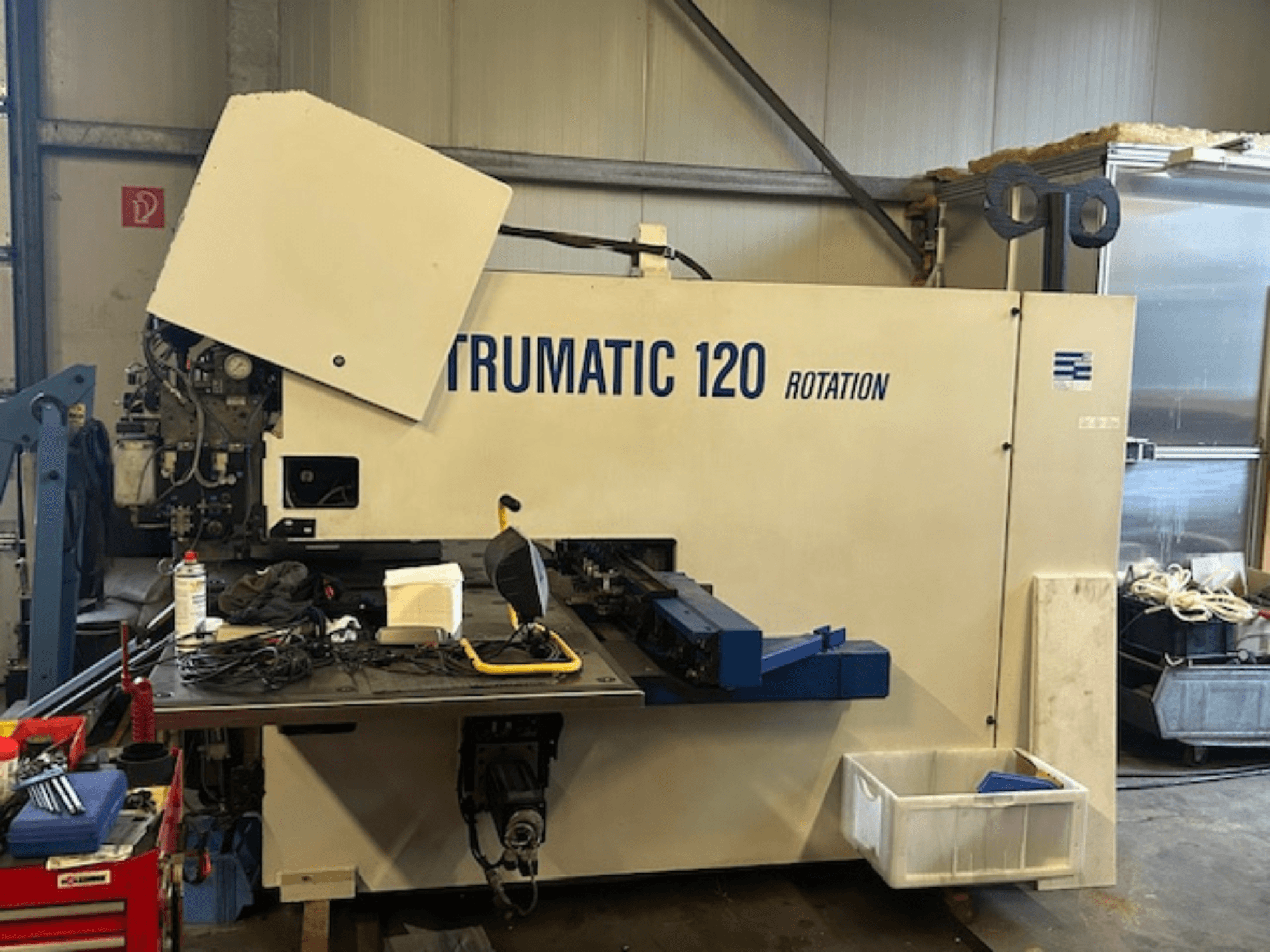 TRUMPF Trumatic 120R CNC lyukasztógép egy műhelyben, elölnézetben a vezérlőpanel és a szerszámok az asztalon.