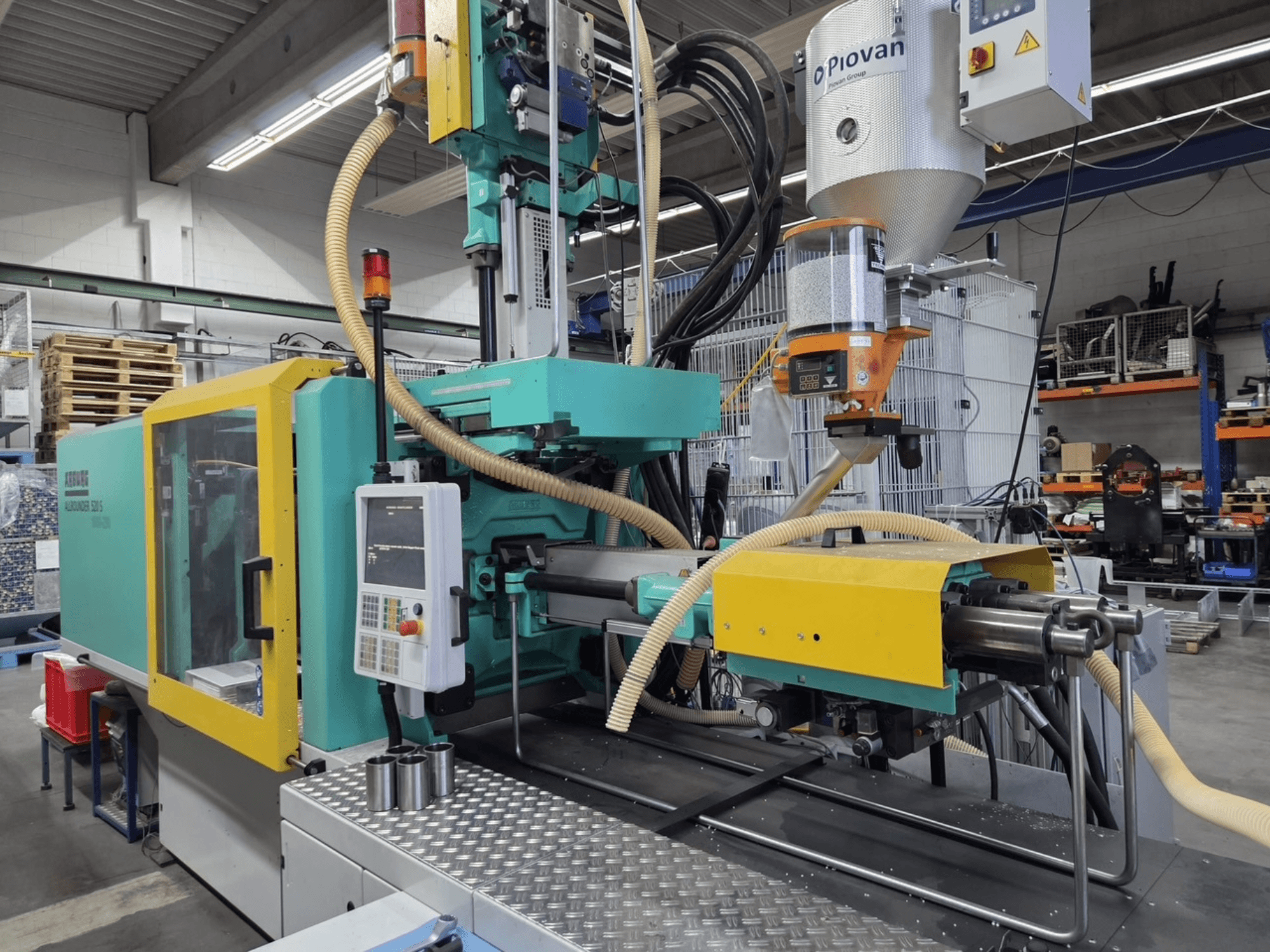 Arburg Allrounder 520 S 1600-290 hidraulikus fröccsöntőgép, elölnézetből, a vezérlőpanel és az anyagadagoló látható.