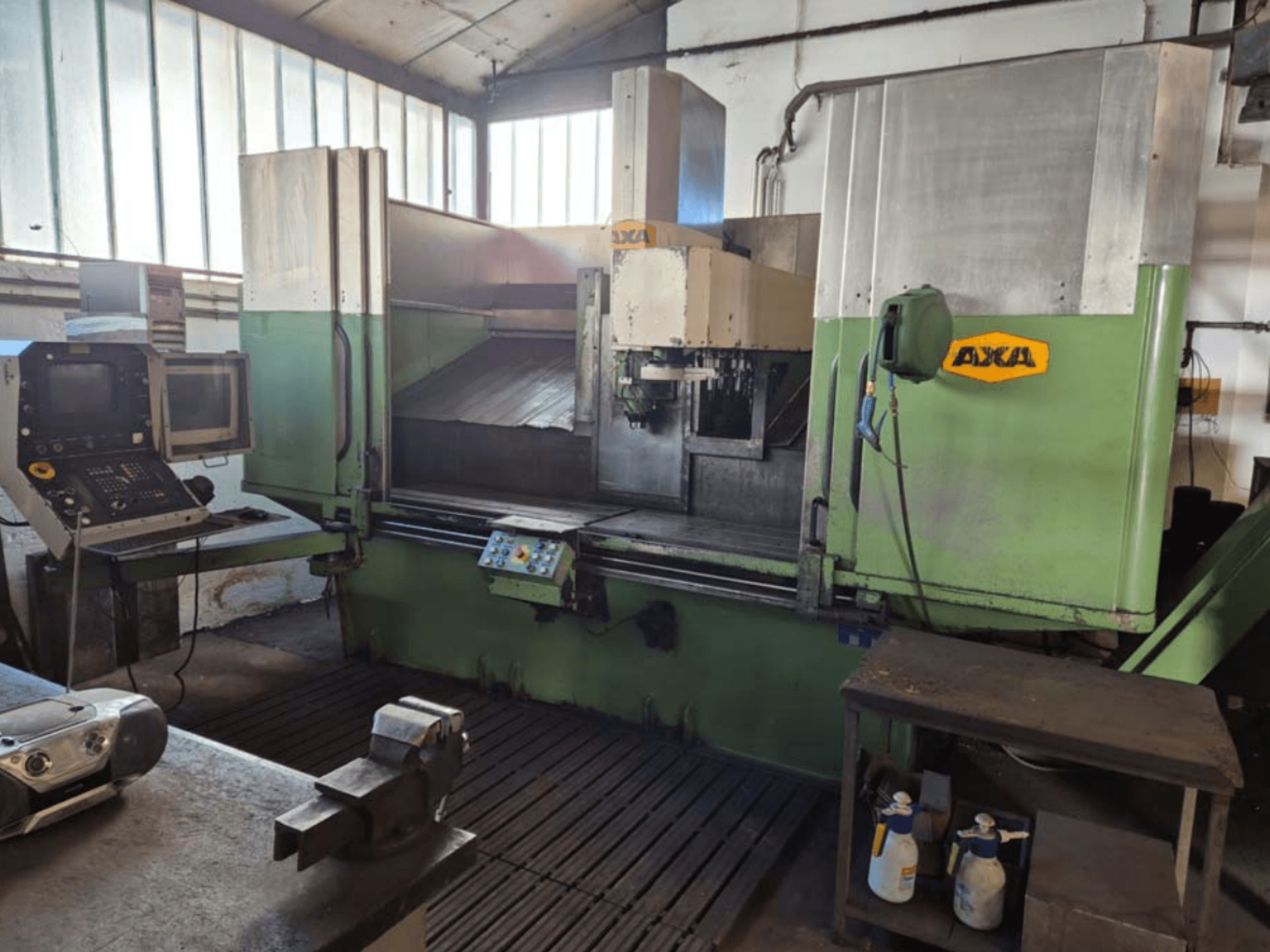 AXA VSC-2M függőleges megmunkálóközpont, elölnézet, vezérlőpanel és munkaterület vágószerszámokkal és tisztítószerekkel.