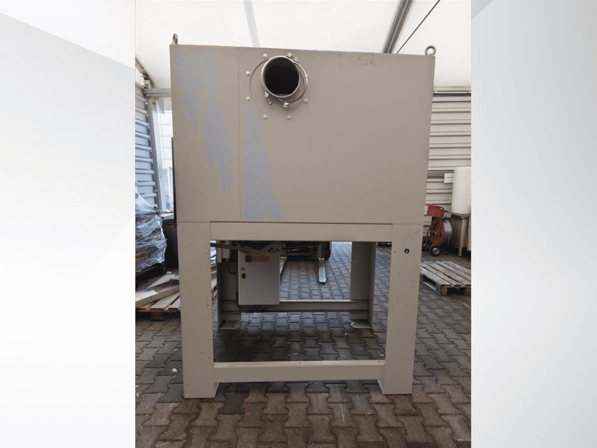 Szürke ipari porgyűjtő szemből nézve, nagy kerek nyílással és masszív talapzatra szerelve.